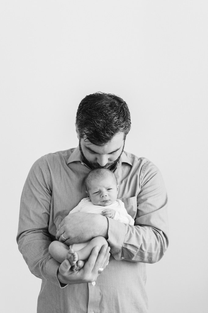 Dad holding baby boy for a picture in the studio.