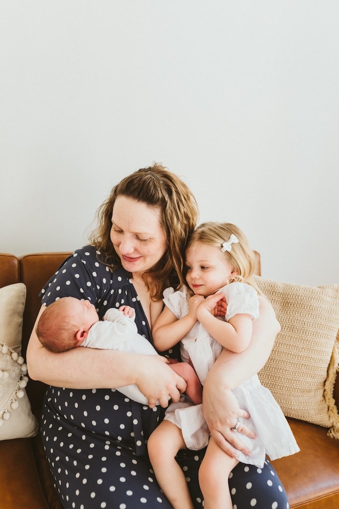 Mom with two kids sitting on a chair.