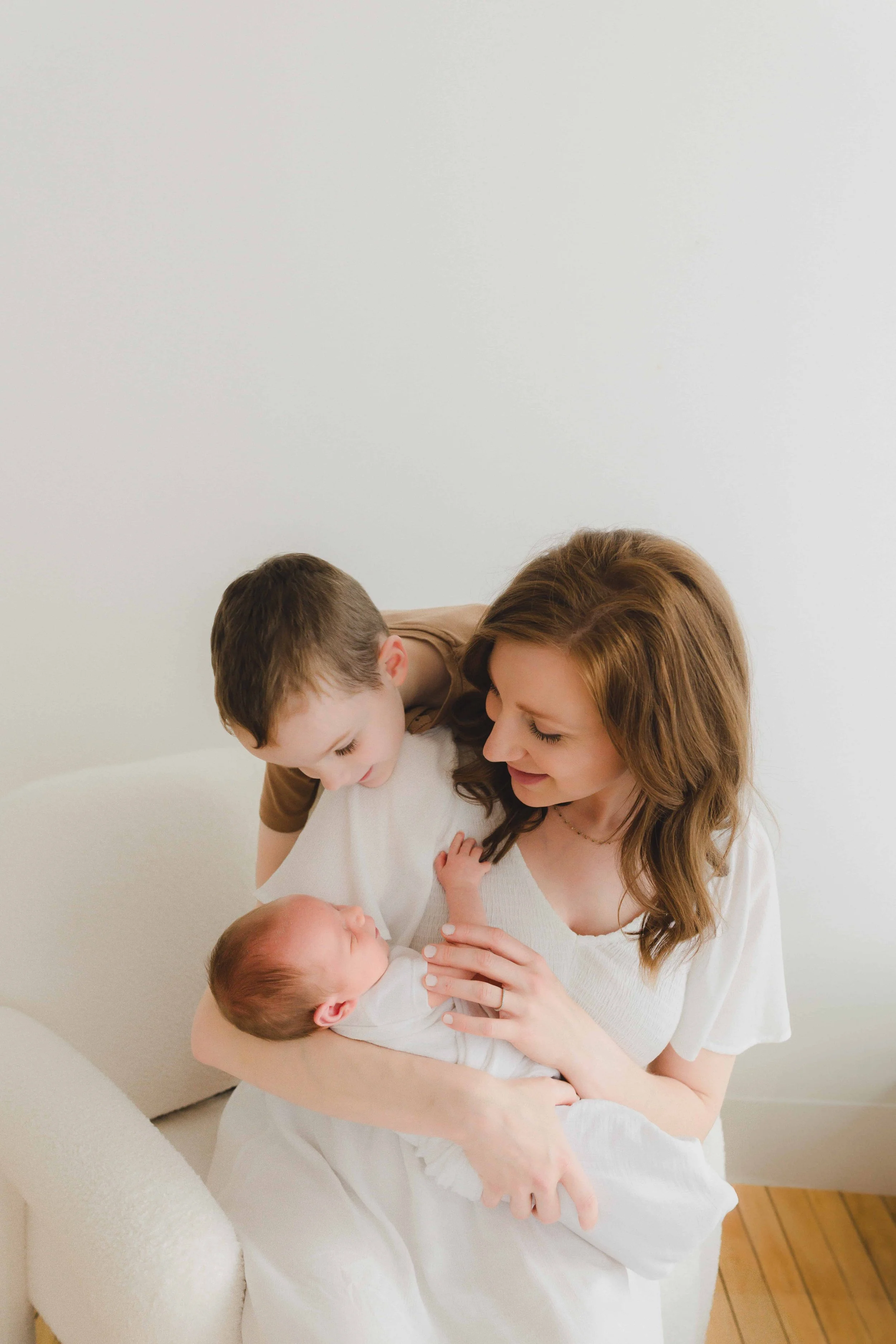 Studio Newborn Photographer Cleveland | Mom and Big Brother Admiring Newborn