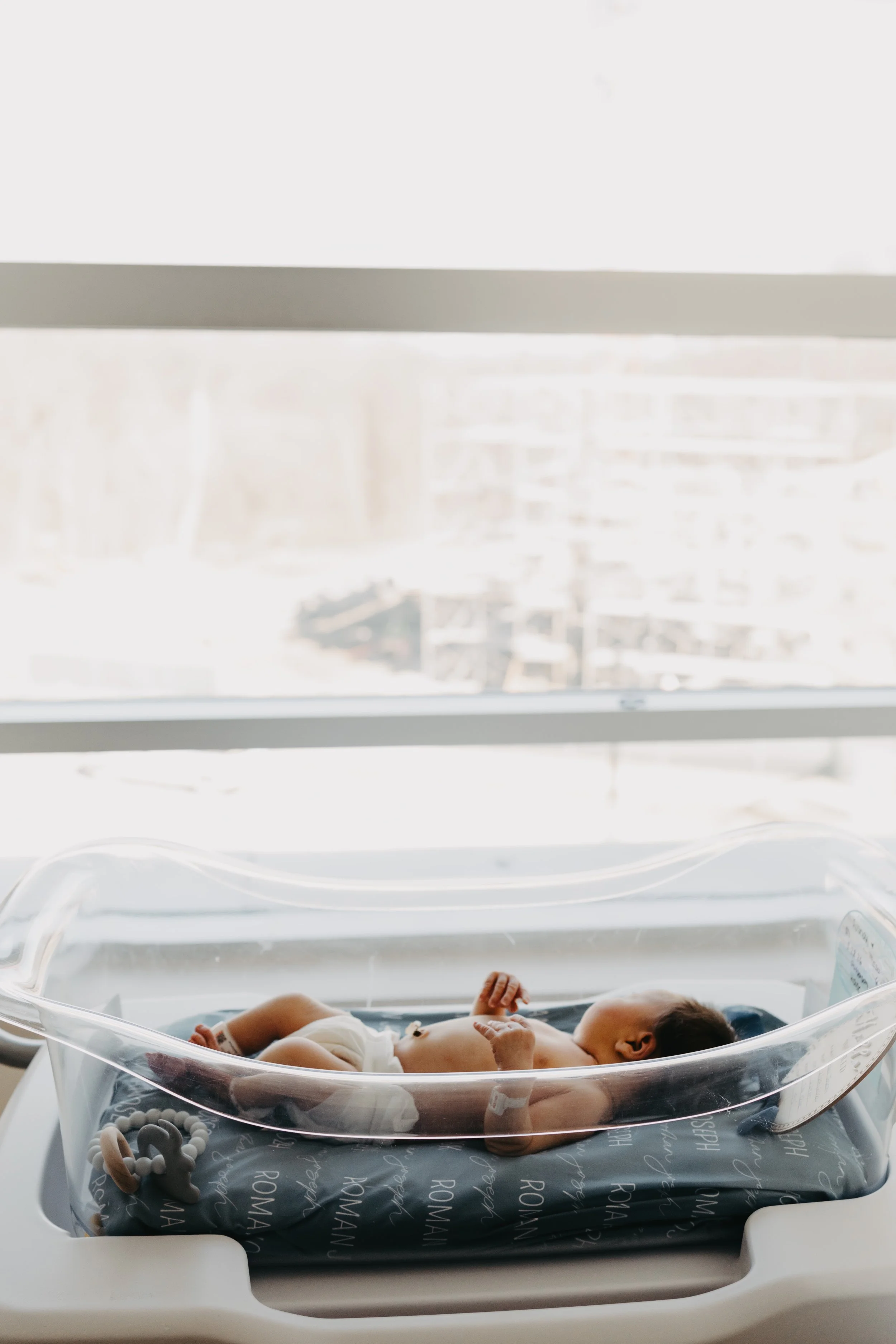 Newborn baby with hospital bracelet in bassinet during Fresh 48 newborn session in Cleveland.