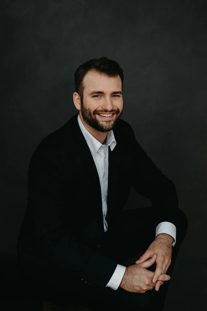 A professional headshot portrait of a man in black suit posing for branding content to represent his brand and talent. Headshot in Cleveland, Ohio studio.
