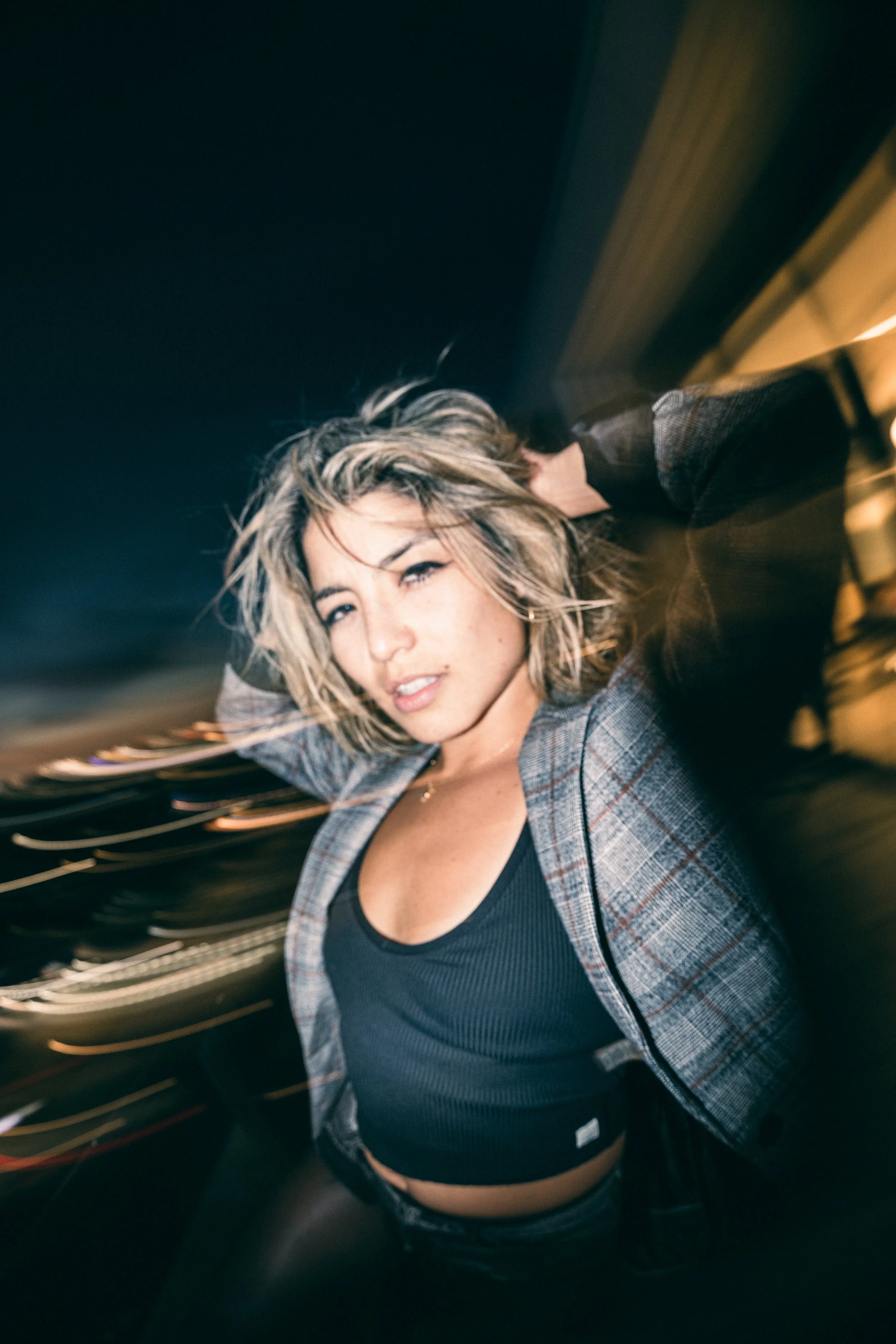 Model, Kim Gonzalez, on a PDX rooftop at sunset posing with a Calvin Klein jacket and long exposure. Portland fashion photography by JP Bogan. Photo taken with with a Venus Optics Laowa 8-15mm f/2.8 Fisheye Lens and a Canon R5.
