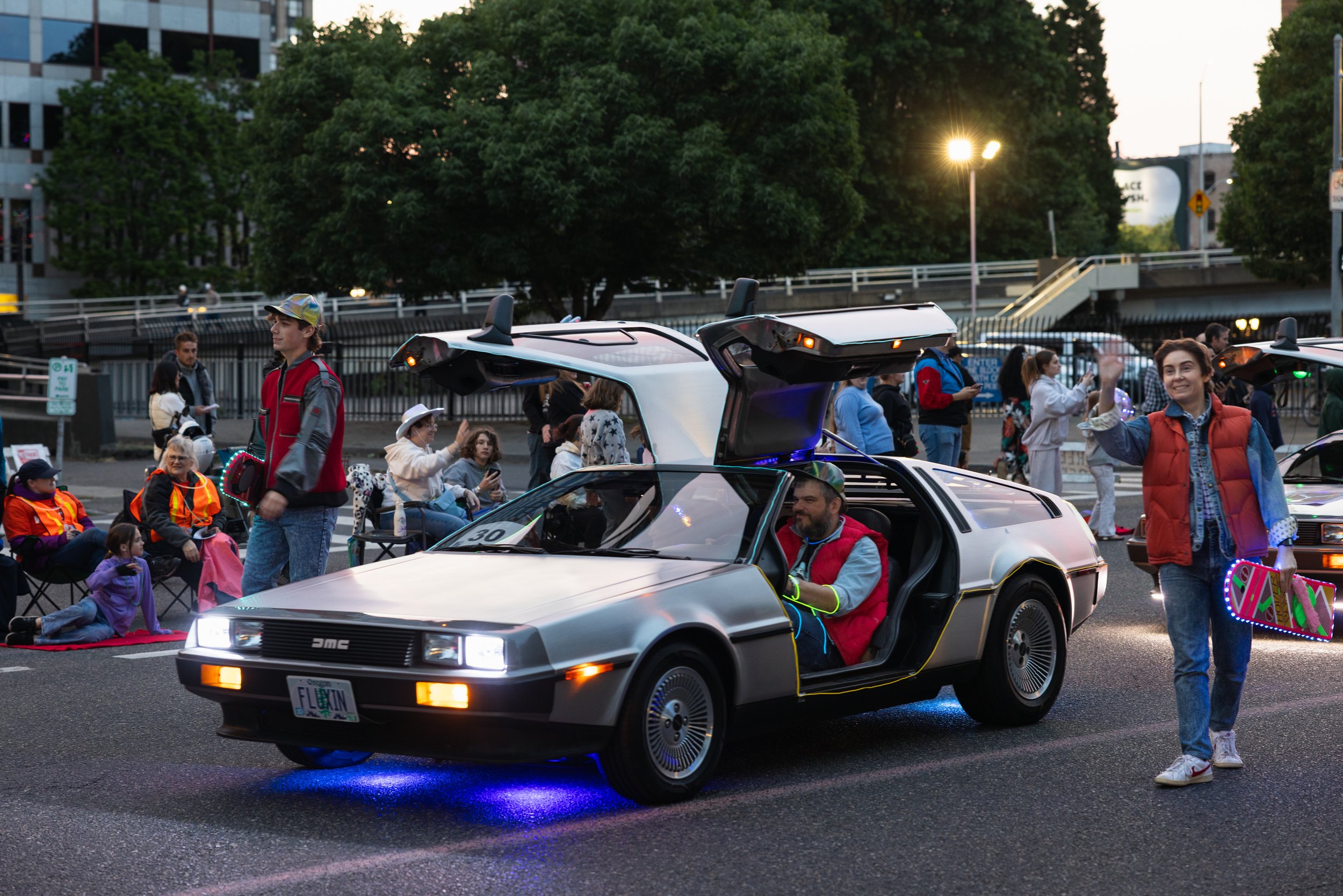 A Delorean with neon lights and Marty McFly driving around in the Starlight Parade in Portland, OR.