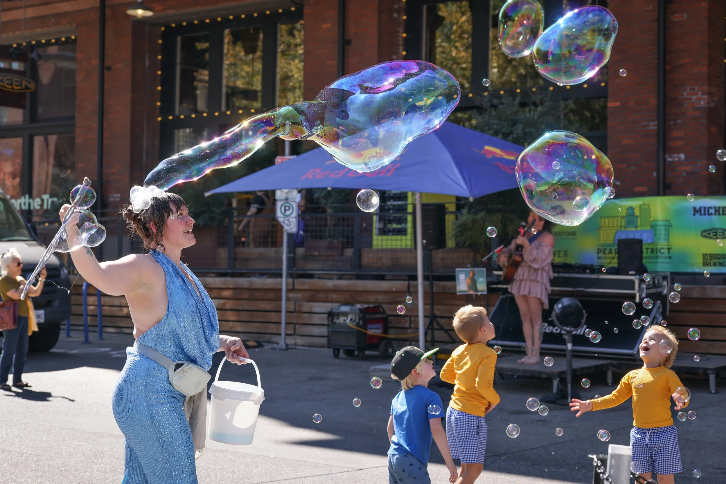 An entertainer making balloons for the kids playing at the Pearl Summer Party in downtown Portland, OR.