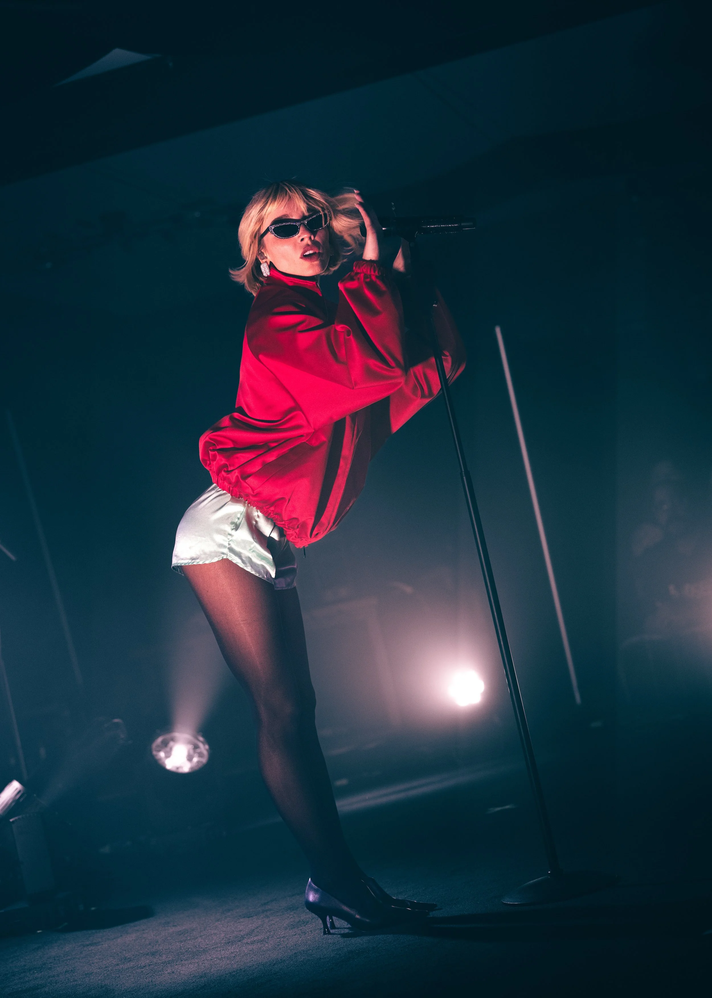 Concert photography of glamorous Goldie Boutilier posing on stage in a red outfit at The Get Down music venue in Portland, OR. 
