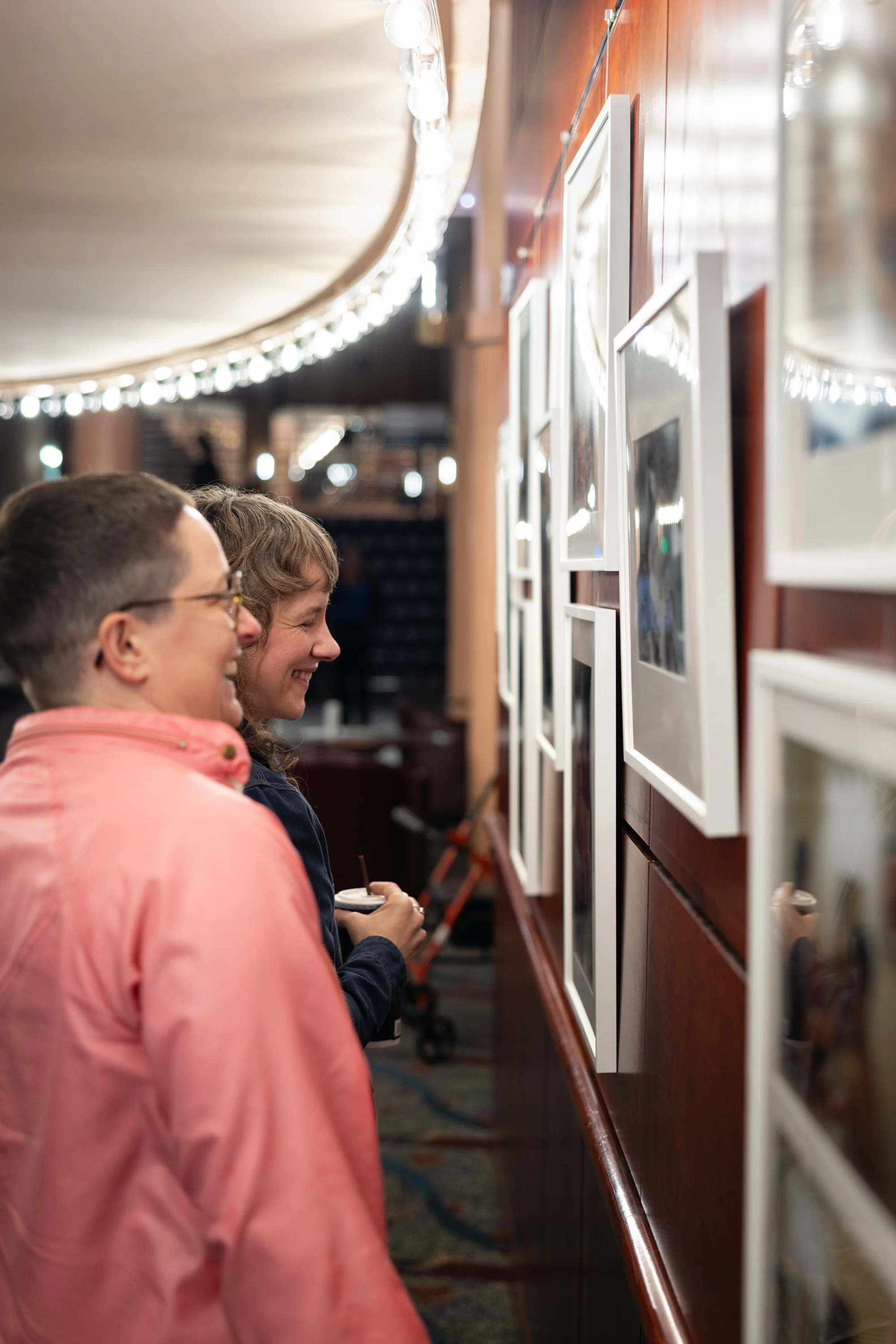 Couple looking at exhibition at Framing Our Presence event at Portland 5 Winningstad Theater in Portland, Oregon. Event Photography bu JP Bogan.