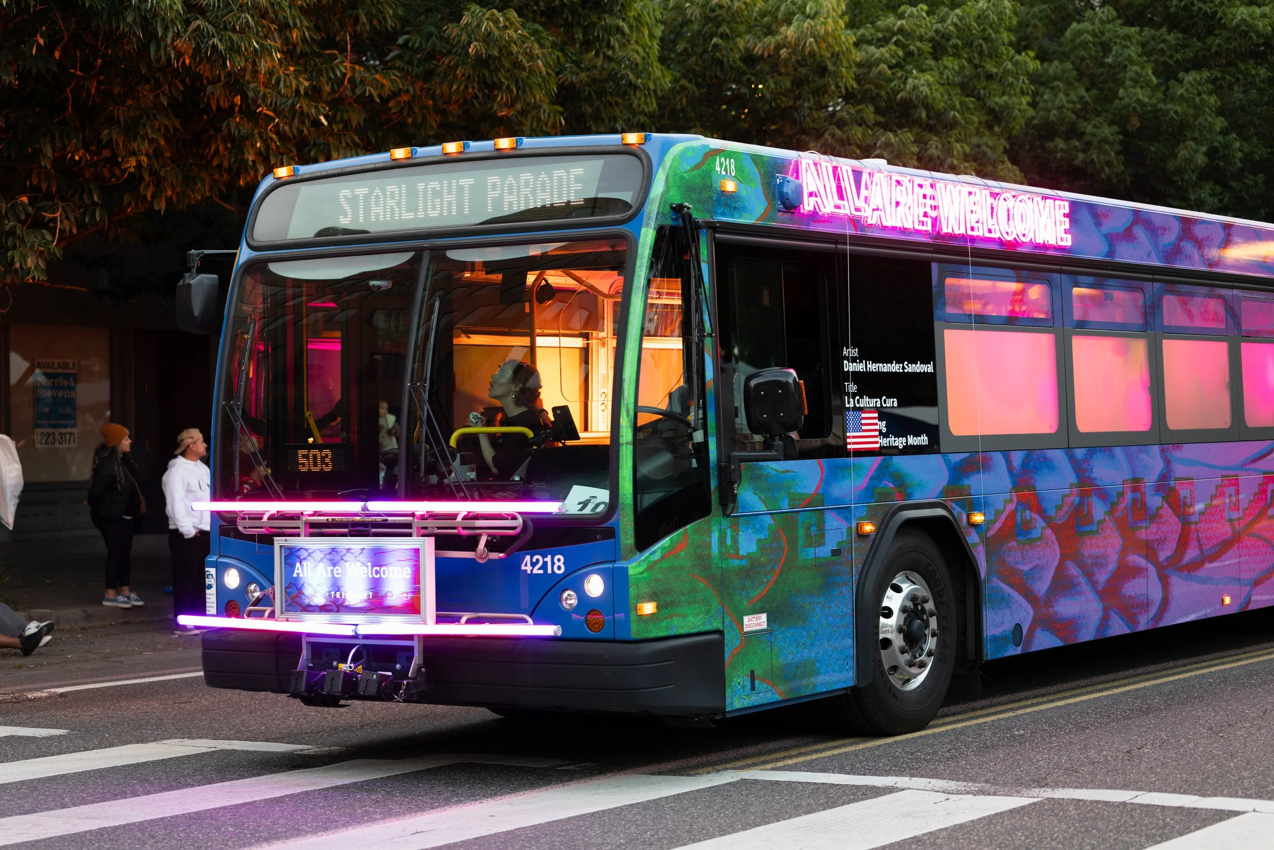 A neon lit city bus driving in the Starlight Parade in Portland, OR.