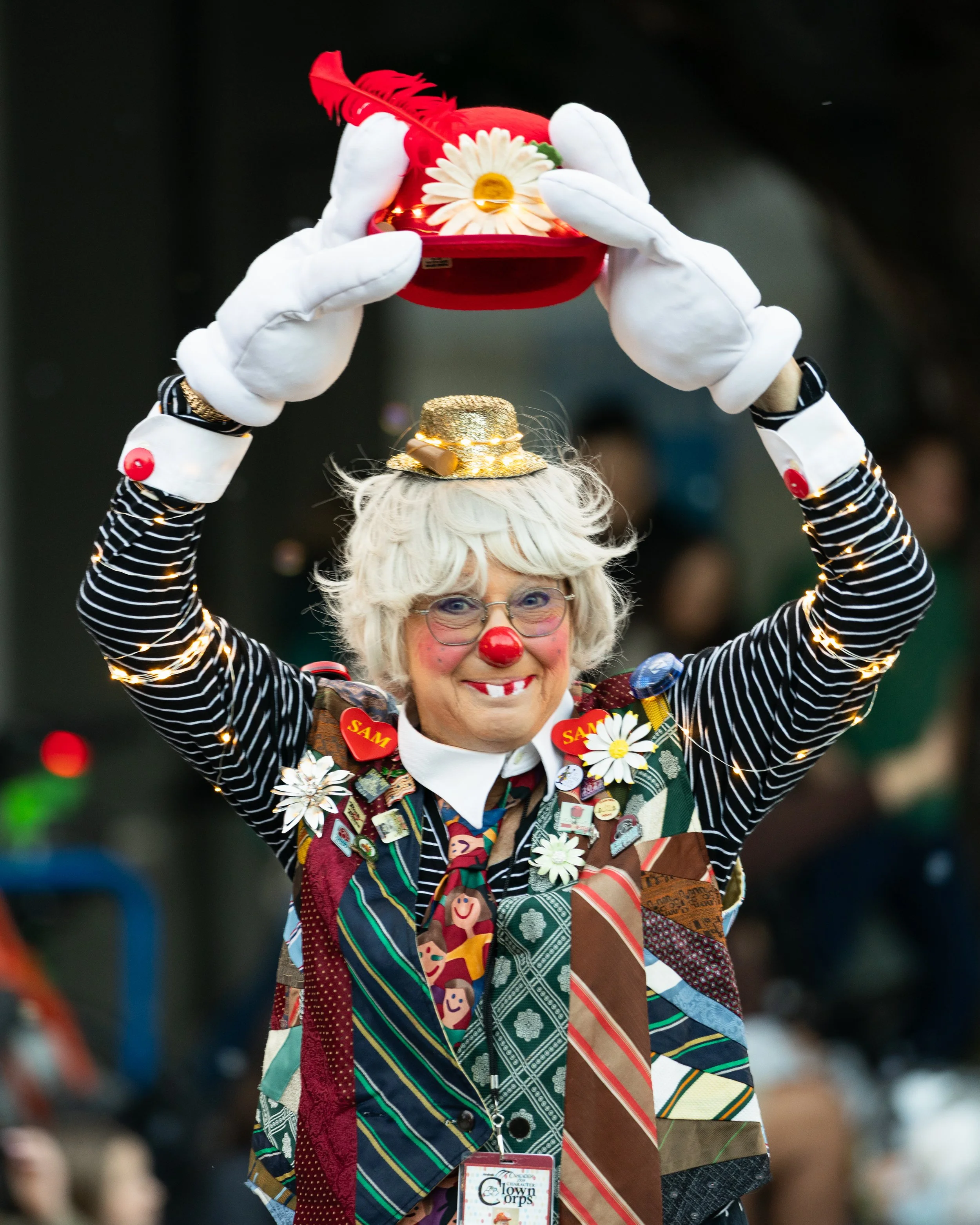 A clown holding up their hat in the Starlight Parade in Portland, OR.