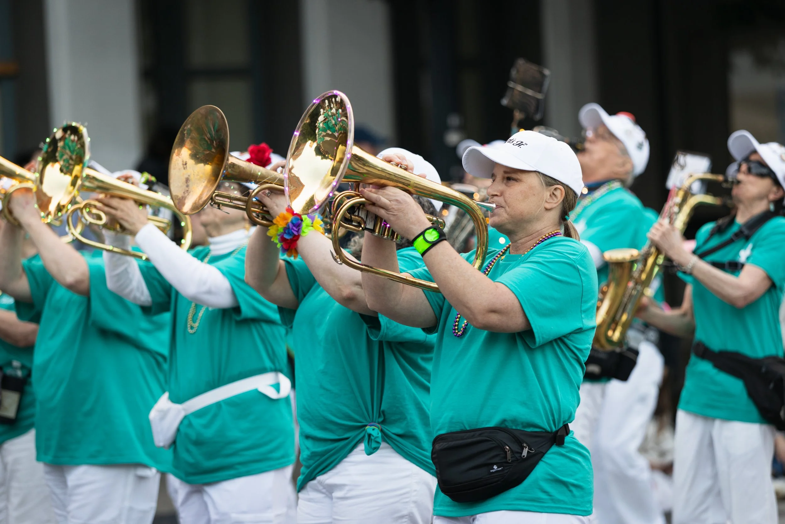 Horn section of a marching band playing music and marching in the Starlight Parade in Portland, OR.
