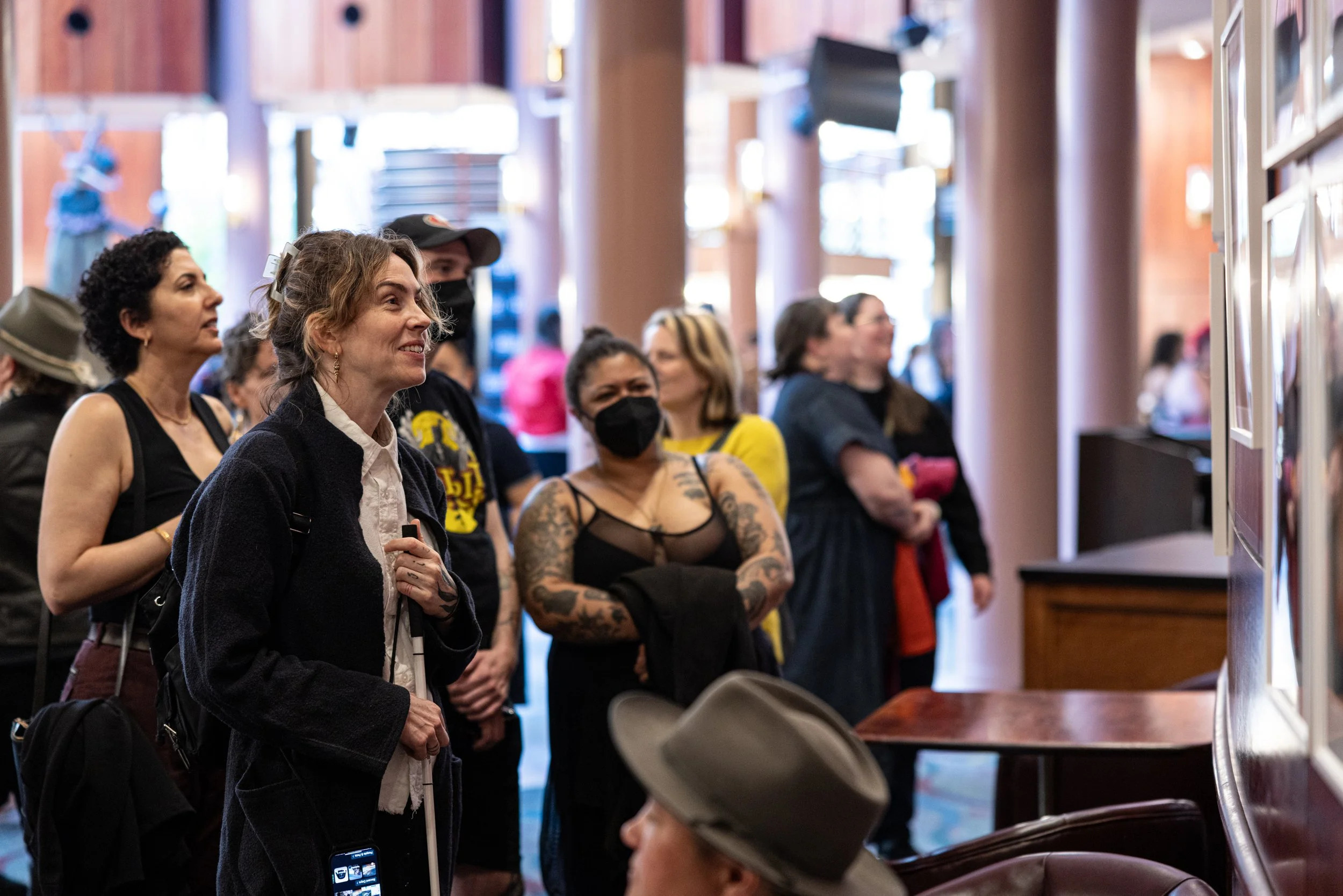 Woman taking in exhibition at Framing Our Presence event at Portland 5 Winningstad Theater in Portland, Oregon. Event Photography bu JP Bogan.