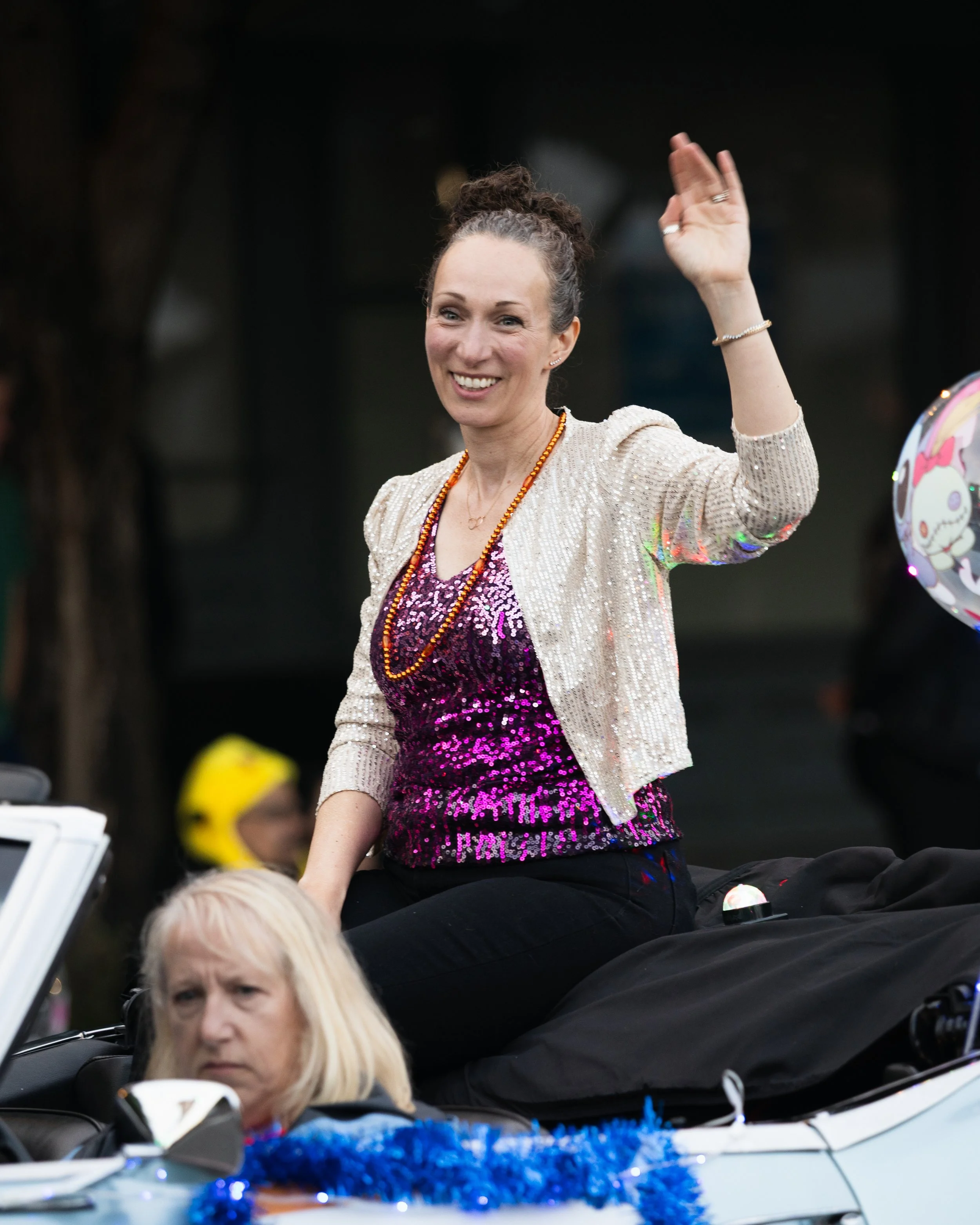 A city counselor, Elana Pirtle-Guiney, waving to people in the Starlight Parade in Portland, OR.