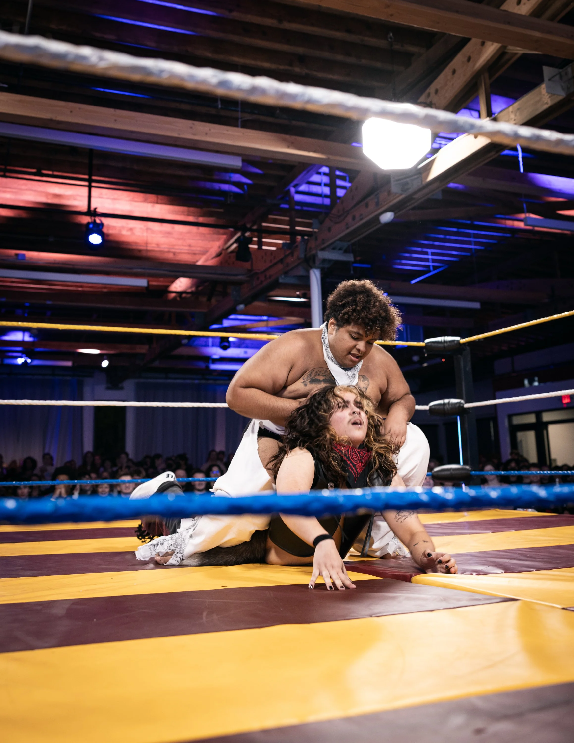 A trans wrestler brutally pinning their opponent in the ring at TBOY Wrestling in Portland, OR.