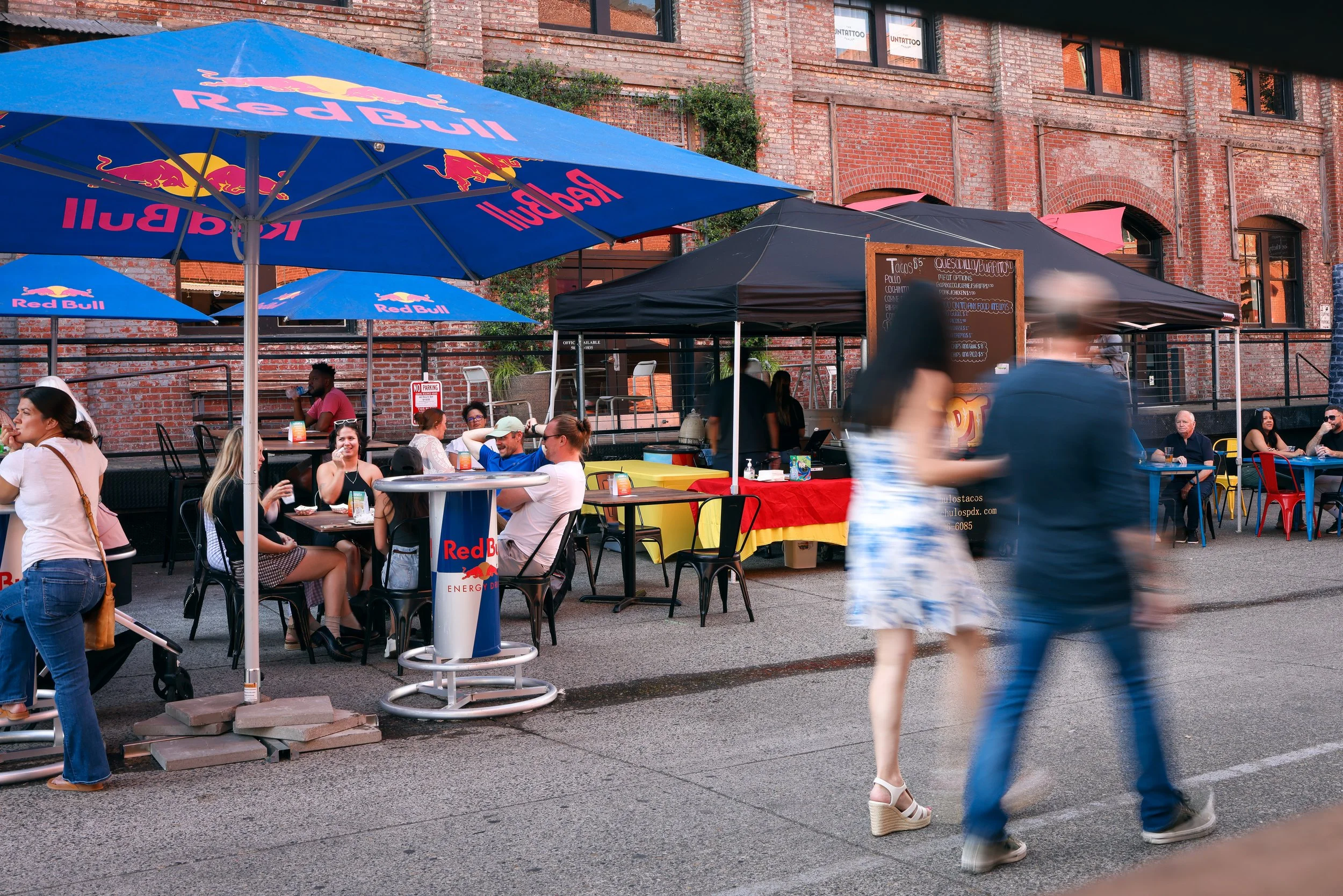 People walking around and eating at the Pearl Summer Party in downtown Portland, OR.