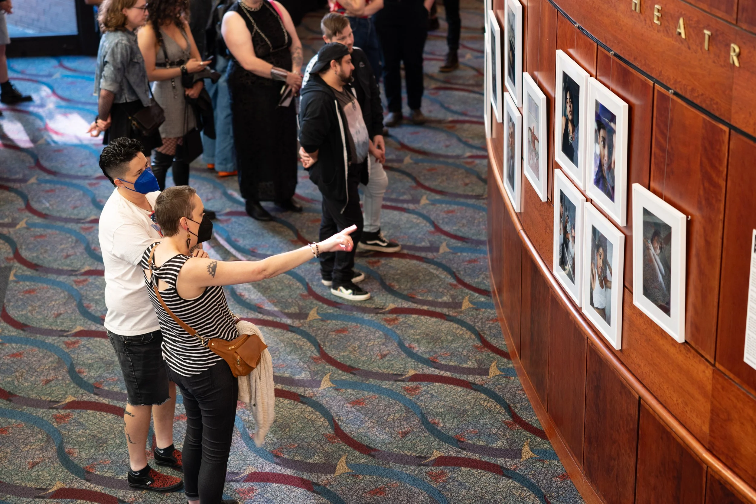 Couple looking at exhibition at Framing Our Presence event at Portland 5 Winningstad Theater in Portland, Oregon. Event Photography bu JP Bogan.
