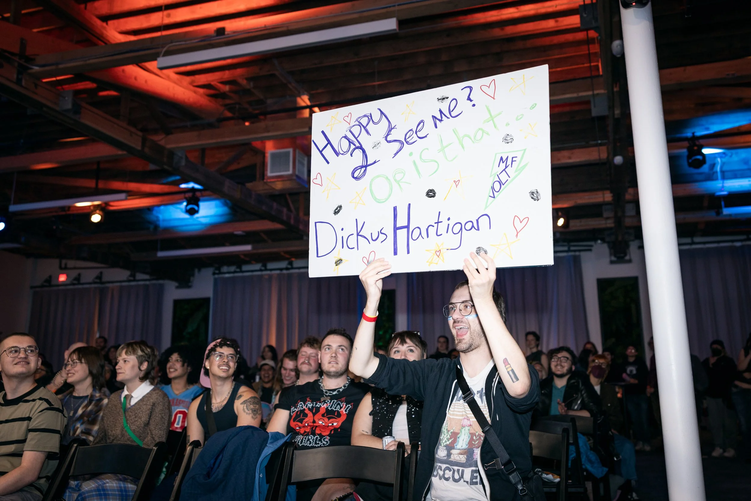 The crowd cheering with a sign at TBOY Wrestling in Portland, OR.