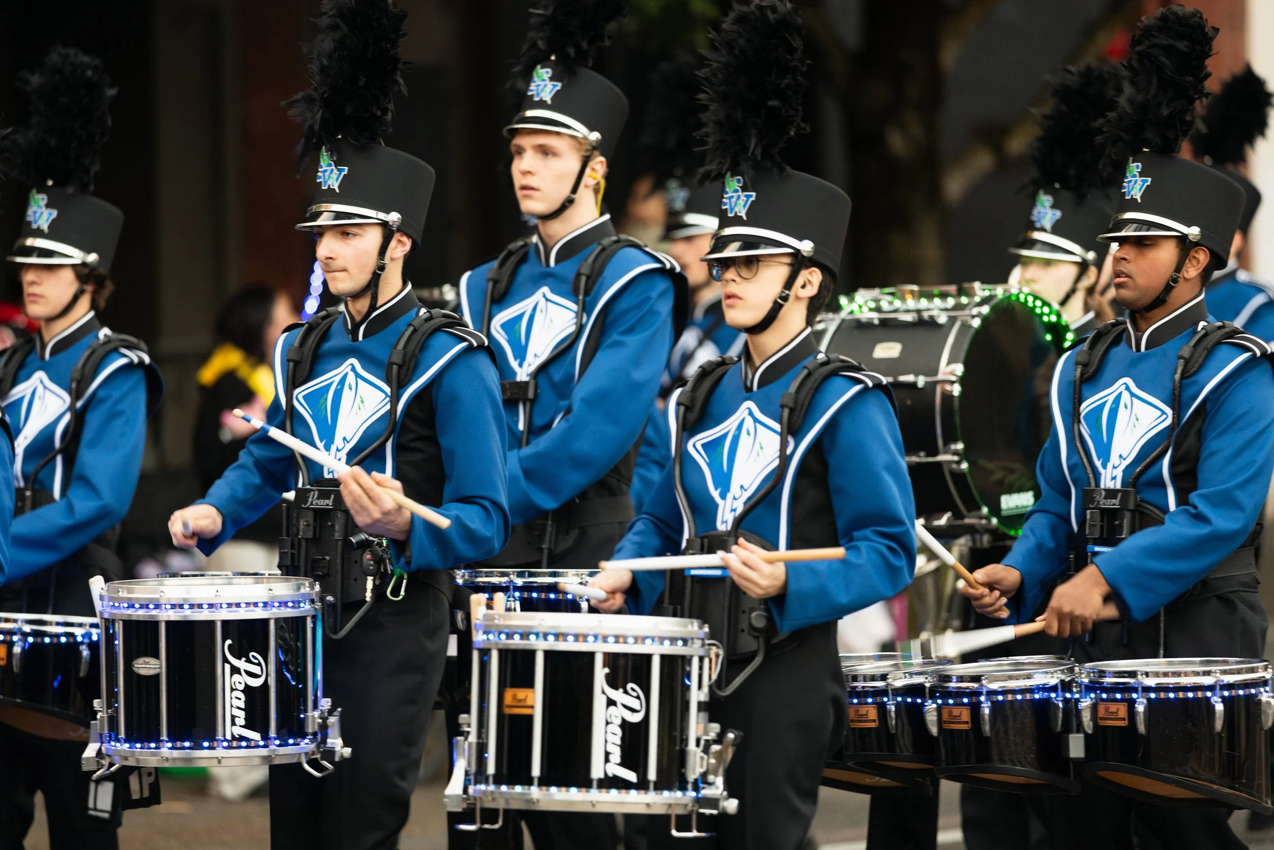 Young marching band in blue marching in the Starlight Parade in Portland, OR.