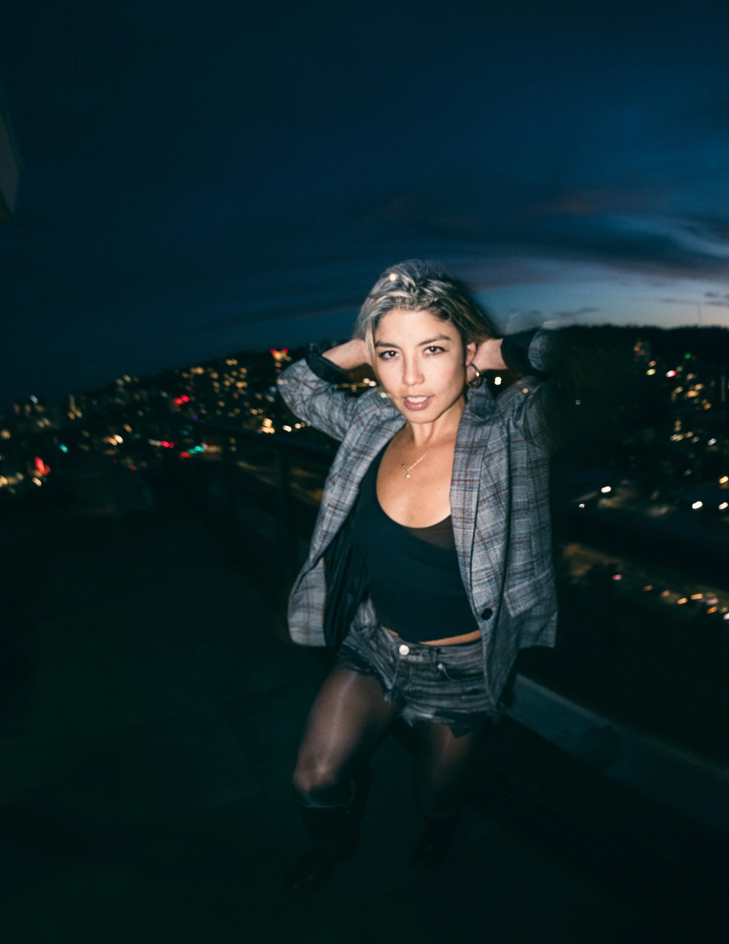 Model, Kim Gonzalez, on a PDX rooftop at sunset posing with a Calvin Klein jacket and long exposure. Portland fashion photography by JP Bogan. Photo taken with with a Venus Optics Laowa 8-15mm f/2.8 Fisheye Lens and a Canon R5.