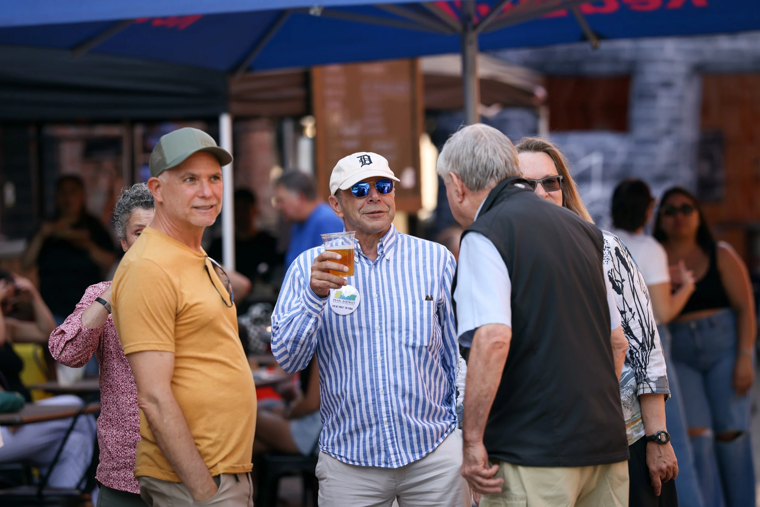 People drinking beers and chatting at the Pearl Summer Party in downtown Portland, OR.
