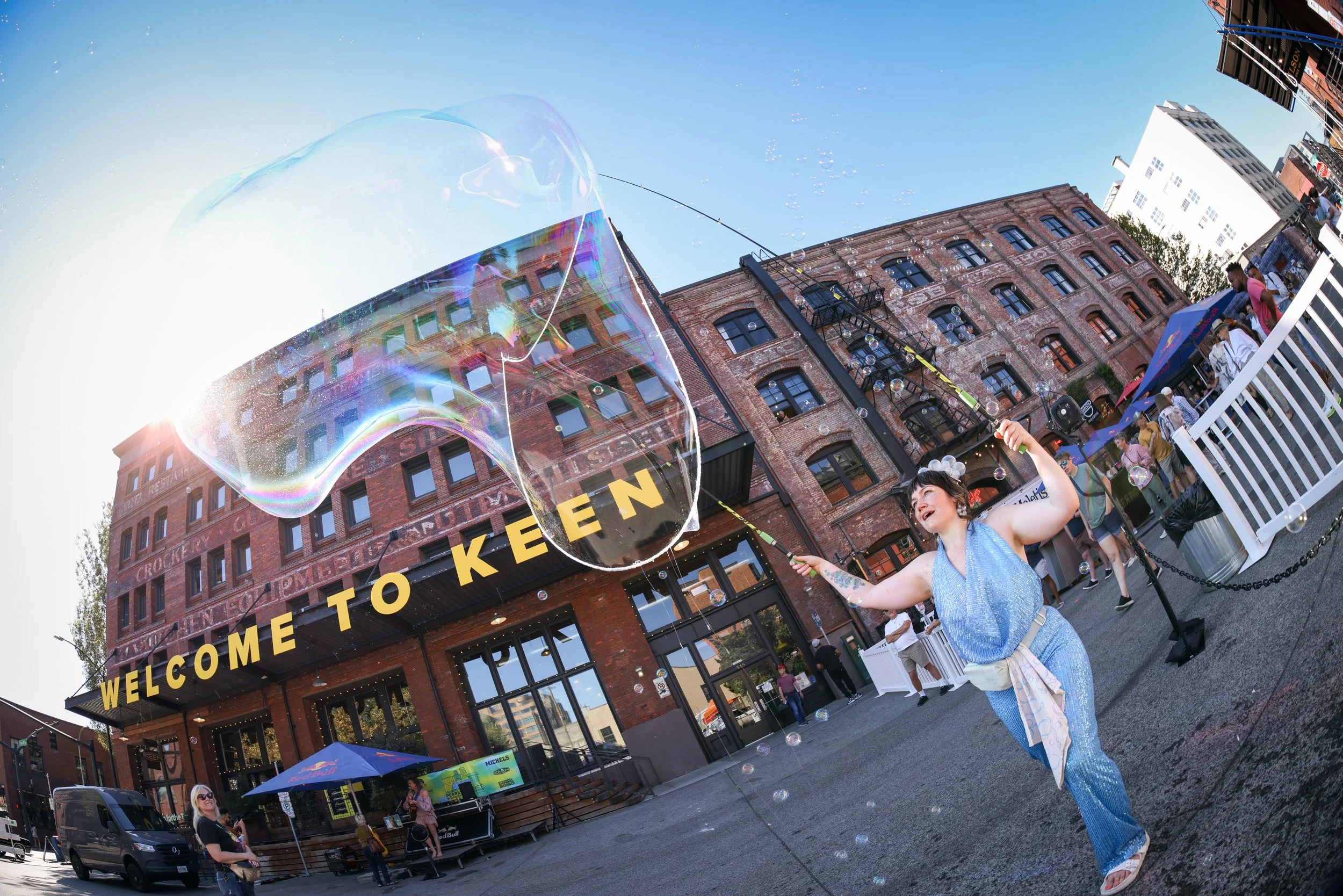 A woman making a large balloon at the Pearl District Summer Party in downtown Portland, Oregon by Rose City Indivisible. Work by Event Photographer by JP Bogan.