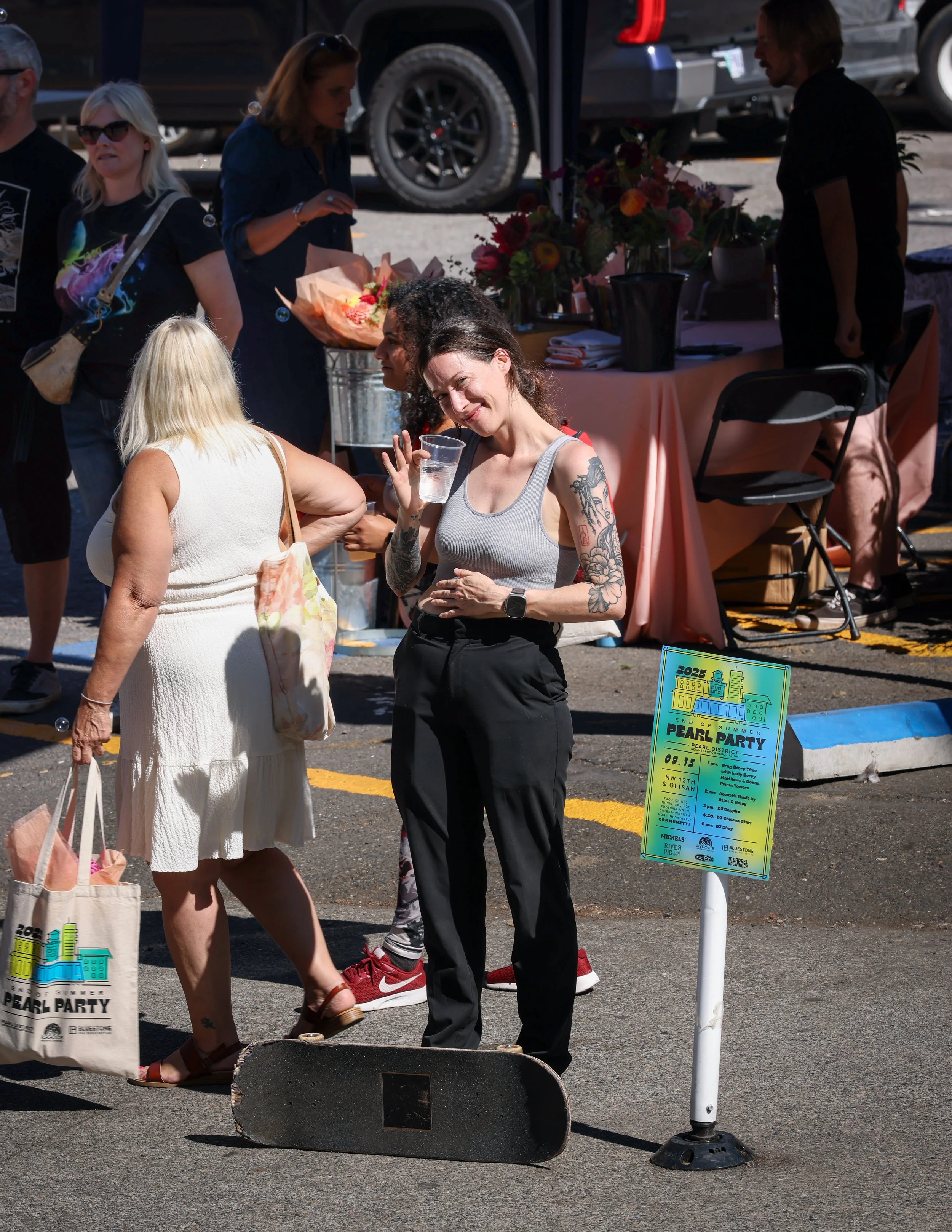 A girl smiling and waving at the Pearl Summer Party in downtown Portland, OR.