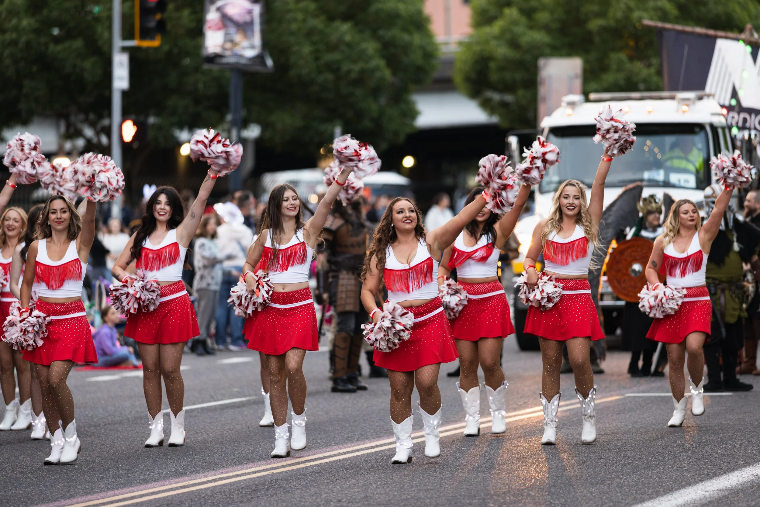 Cheerleaders waving pom poms and dancing in the Starlight Parade in Portland, OR.
