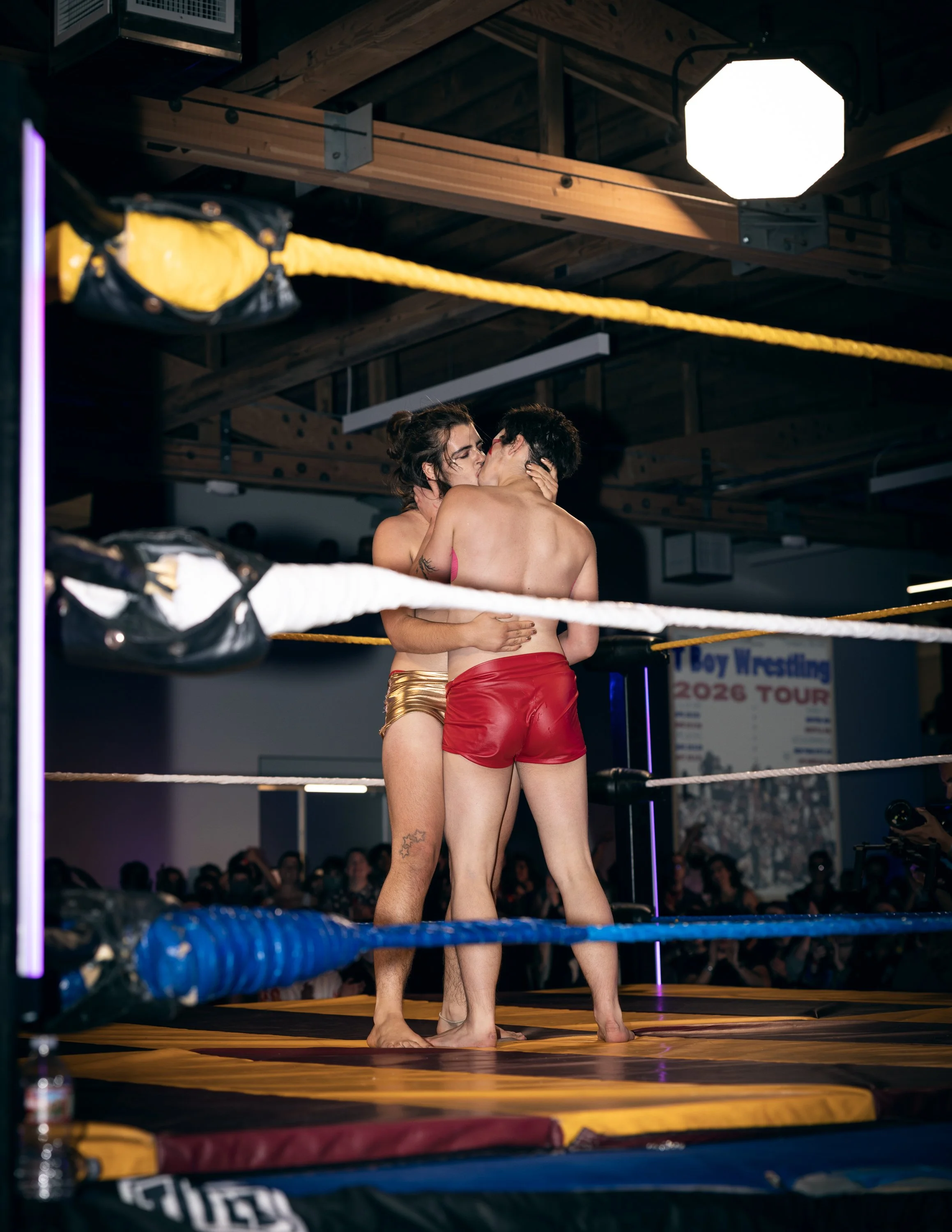 Two wrestlers stopping for a moment of intimate kissing at TBOY Wrestling in Portland, OR.