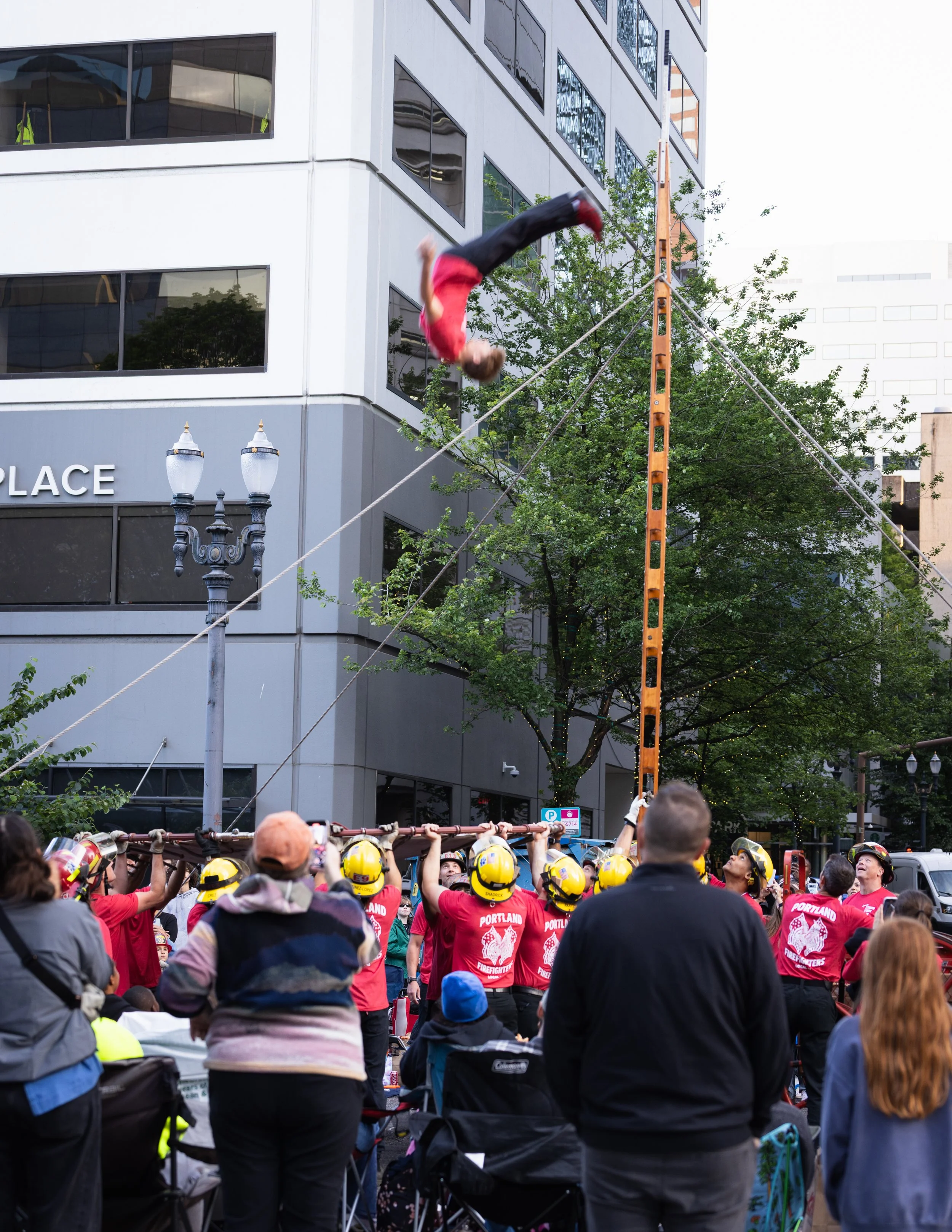 Firefighters catching flipping person in the Starlight Parade in Portland, OR.