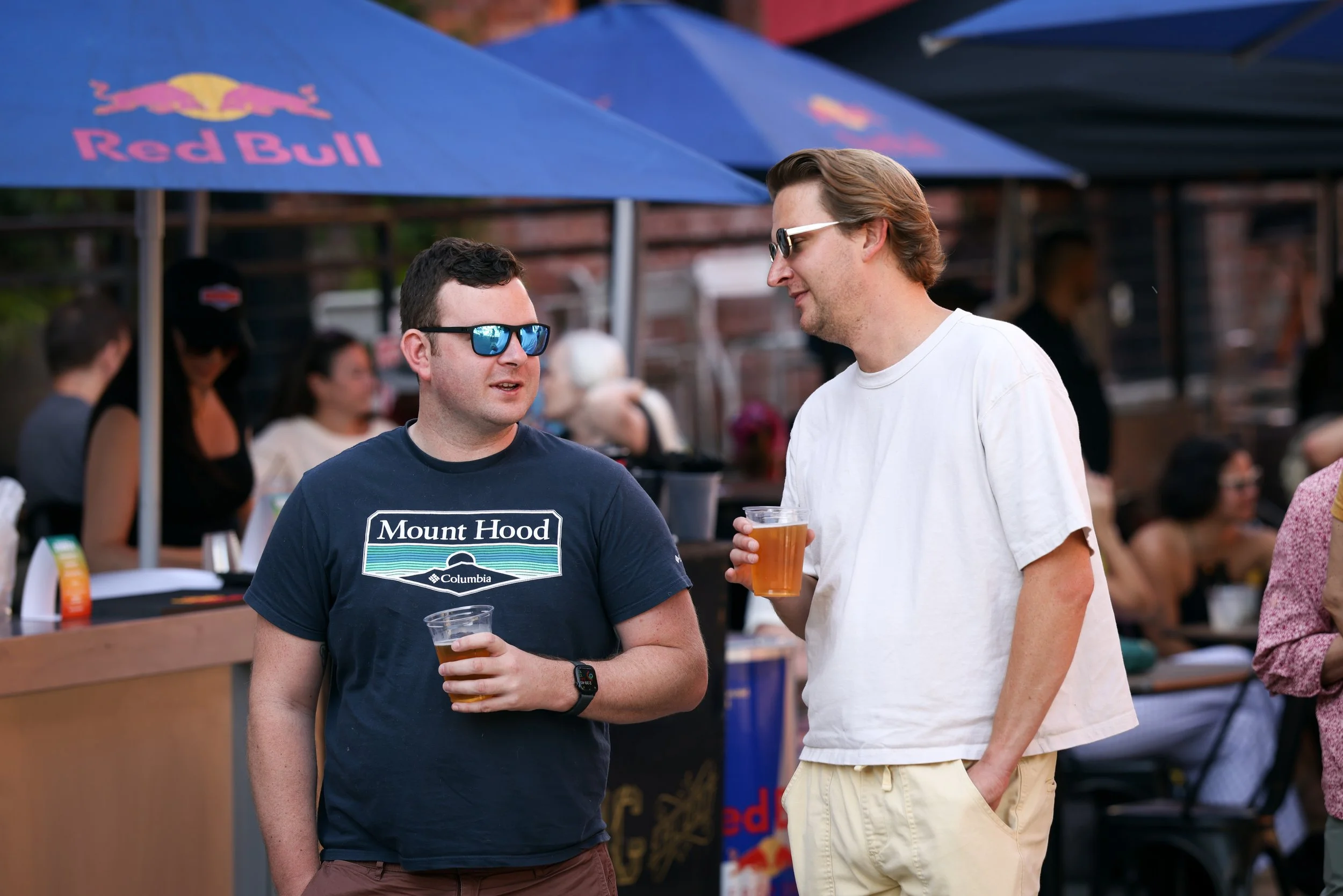 Two men drinking and chatting at the Pearl Summer Party in downtown Portland, OR.