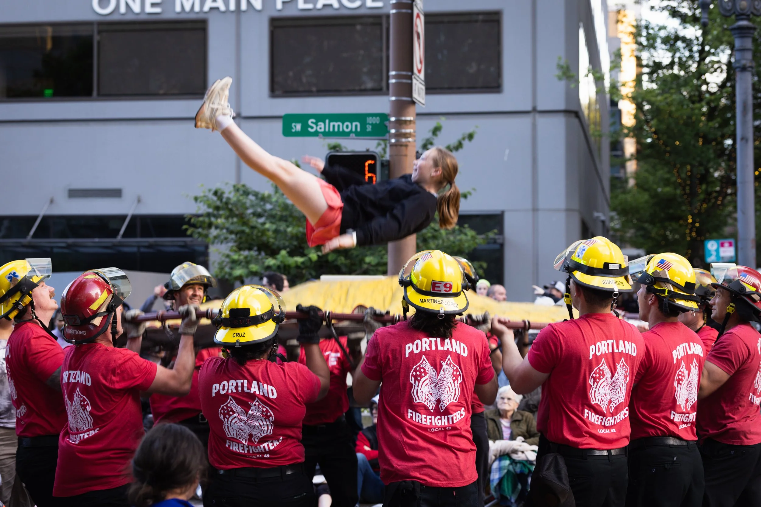 Fire crew bouncing a girl on a trampoline in the Starlight Parade in Portland, OR.