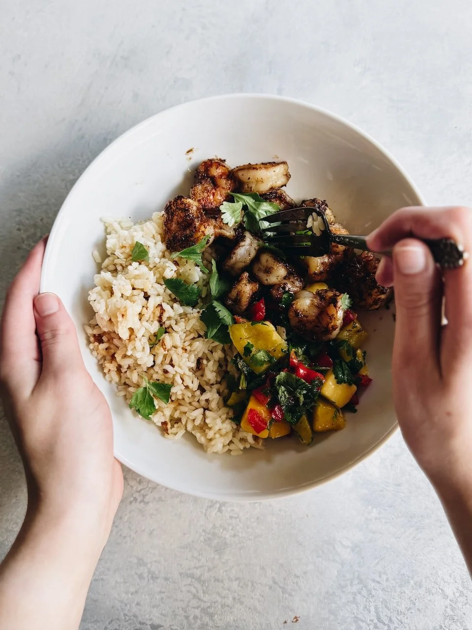 A bowl of jerk seasoned shrimp with rice and mango cilantro salsa.