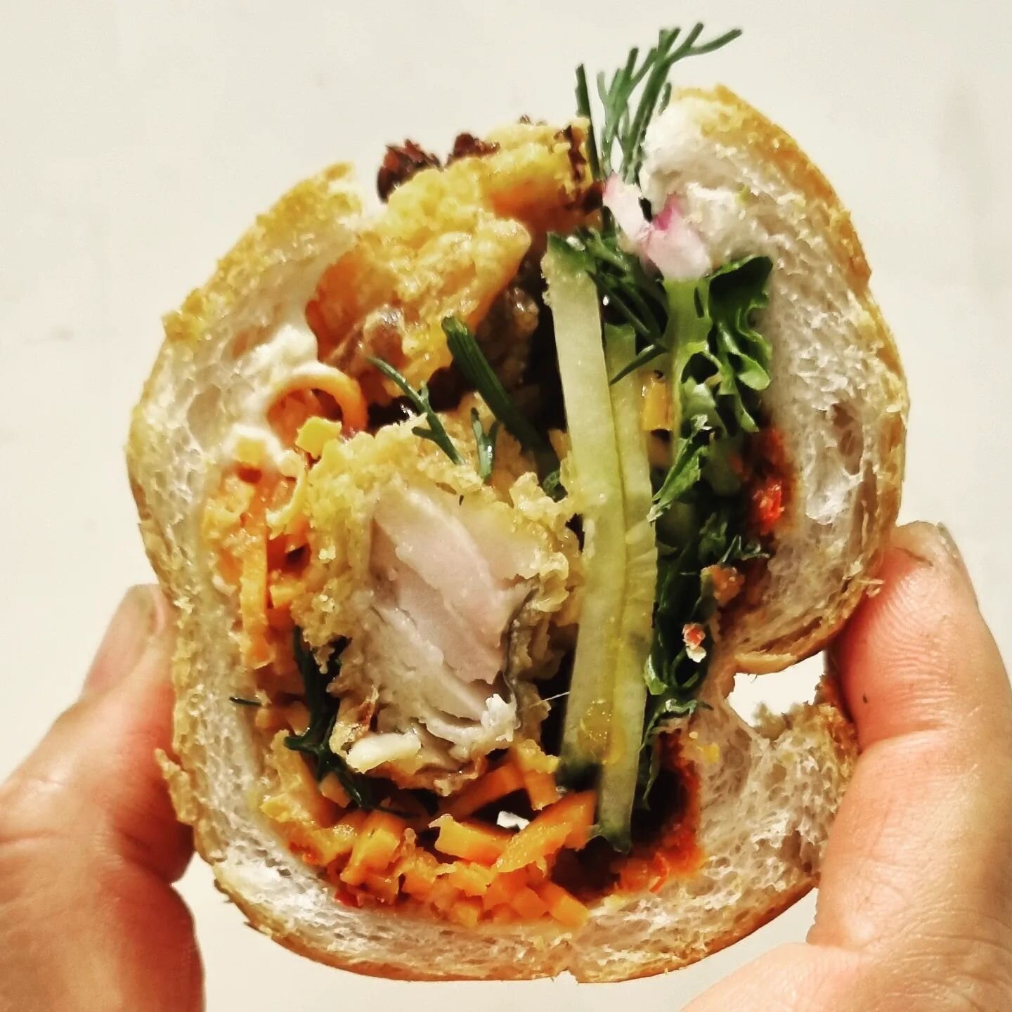 Cross-section of a King Dory banh mi that is available only for today

King Dory fillets dredge in chickpea flour and fried
Lots of dill, red onions and our trademark 🌶 red curry paste and crispy chilli

Like a fillet-o-fish but 🤌🏻