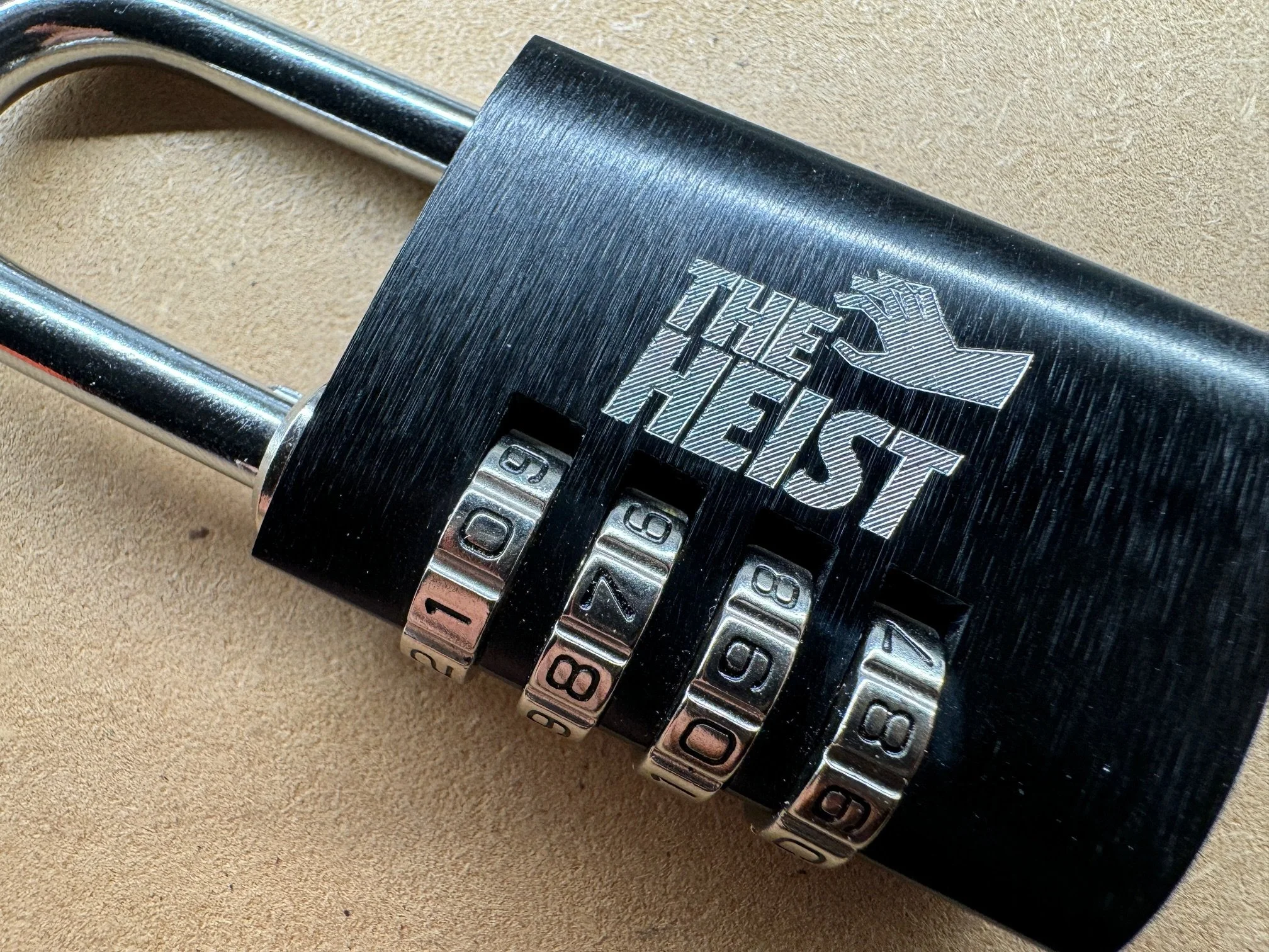 An escape room lock with a logo engraved in the side