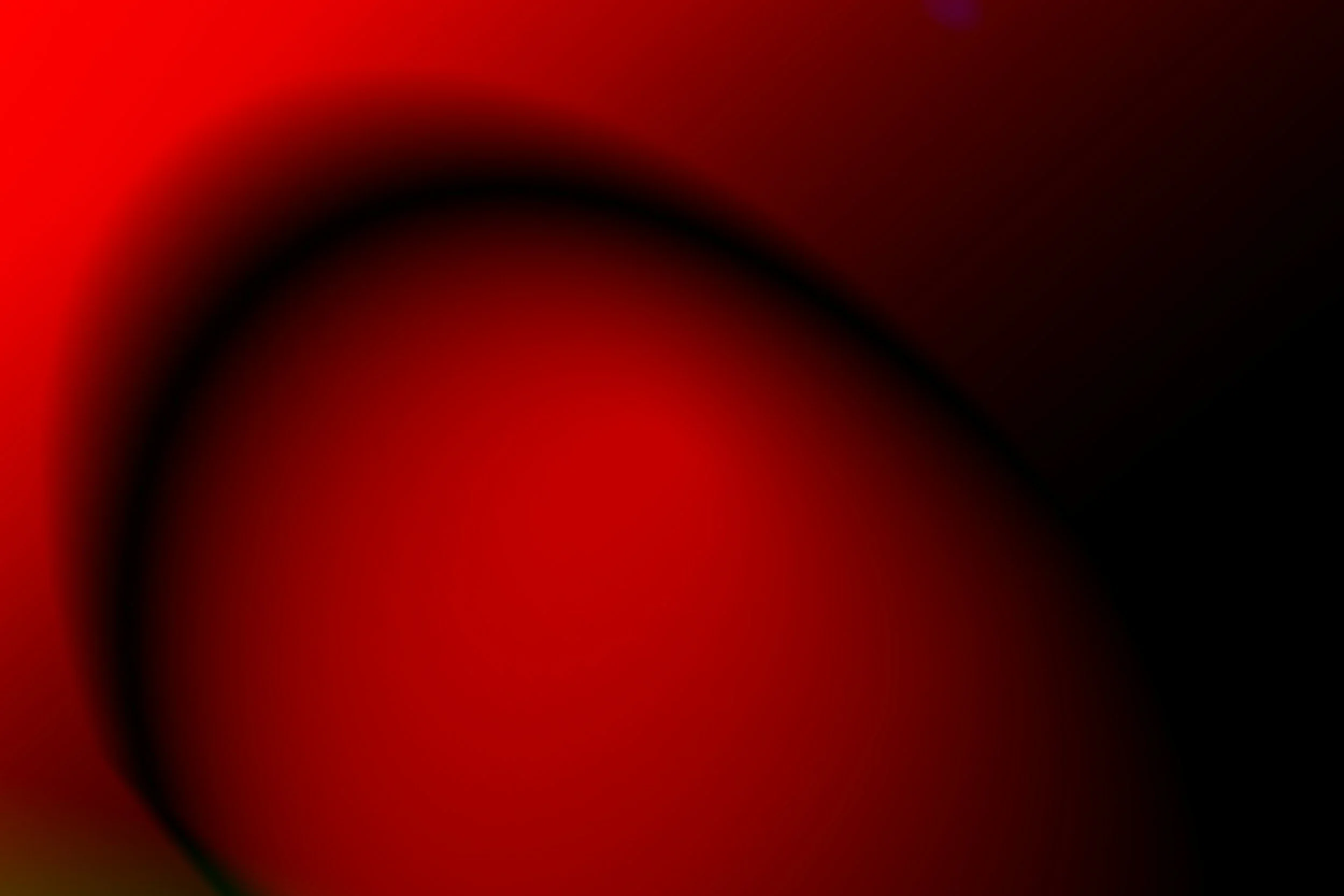 Abstract image with red, black, and dark brown colors blending together in a gradient pattern.