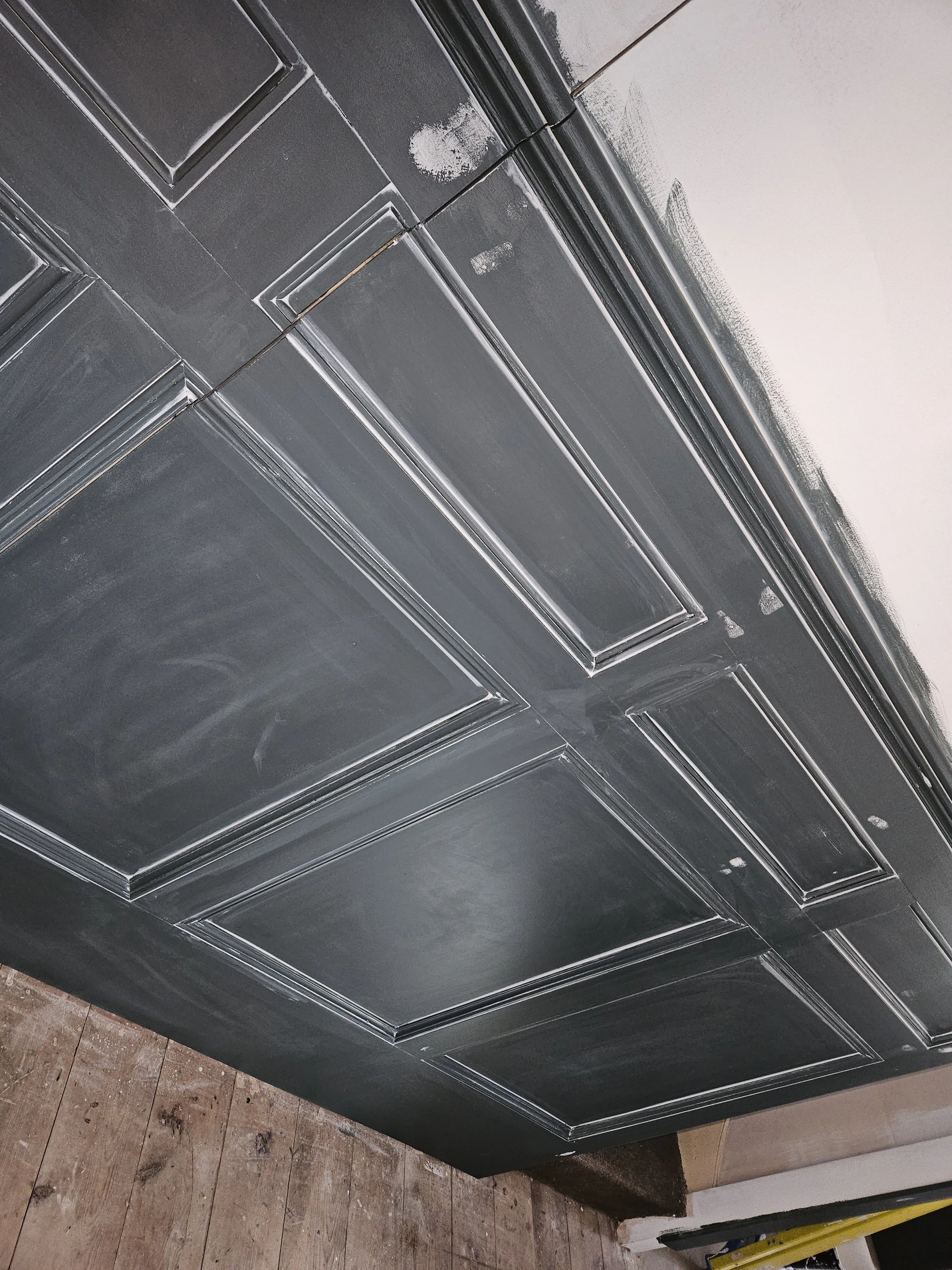 Chalkboard painted to look like a decorative black wood-paneled ceiling.