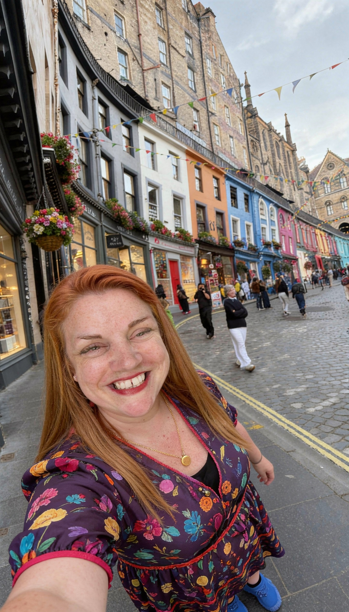 Smiling woman taking a selfie in a colourful street with painted buildings