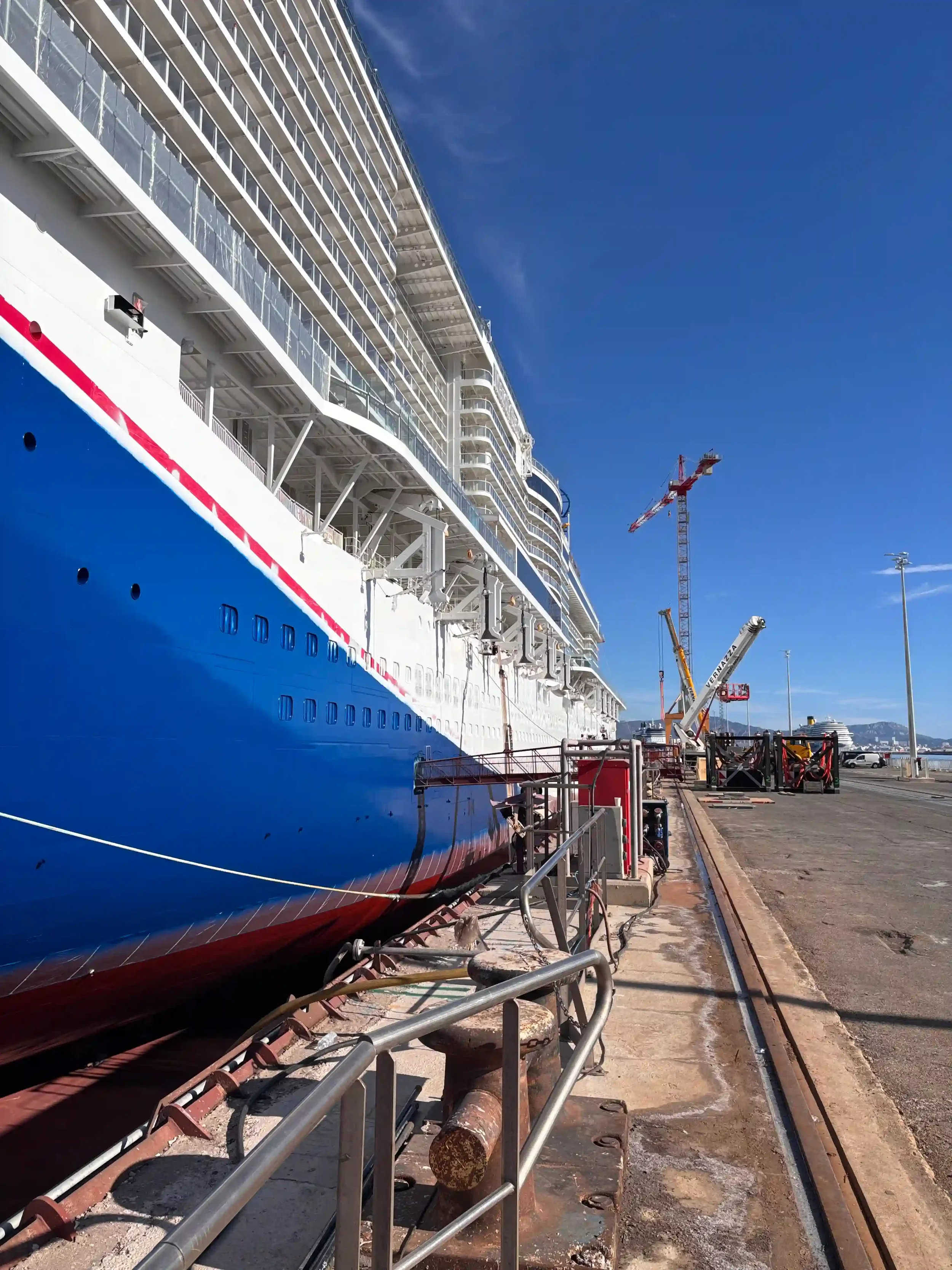 Opérateurs de levage sur un chantier naval réalisant une manutention complexe. Illustration de la pénurie de compétences techniques en industrie lourde.