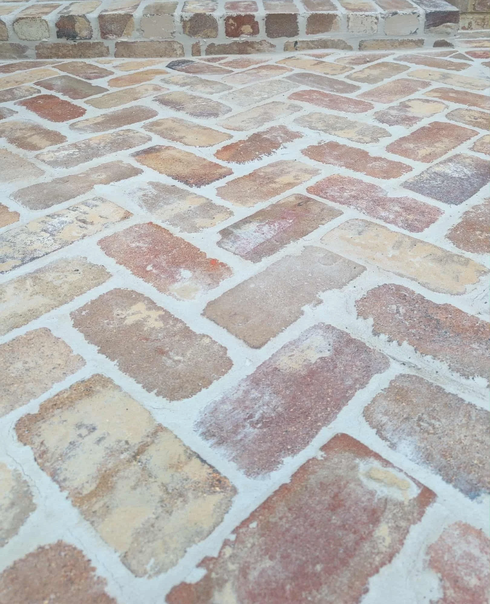 Recycled brick driveway laid in herringbone with grout.