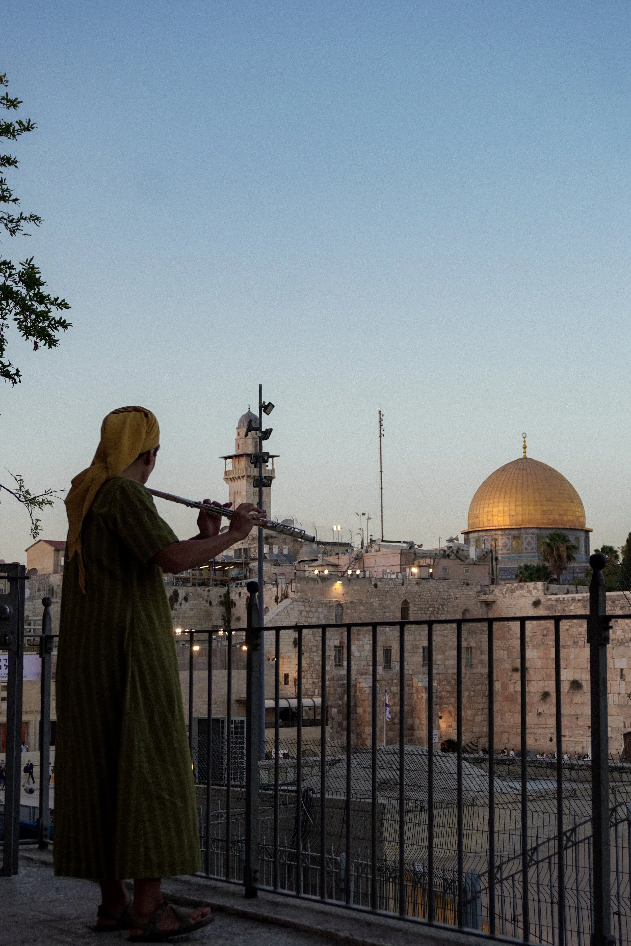woman playing the flute above the western wall plaza