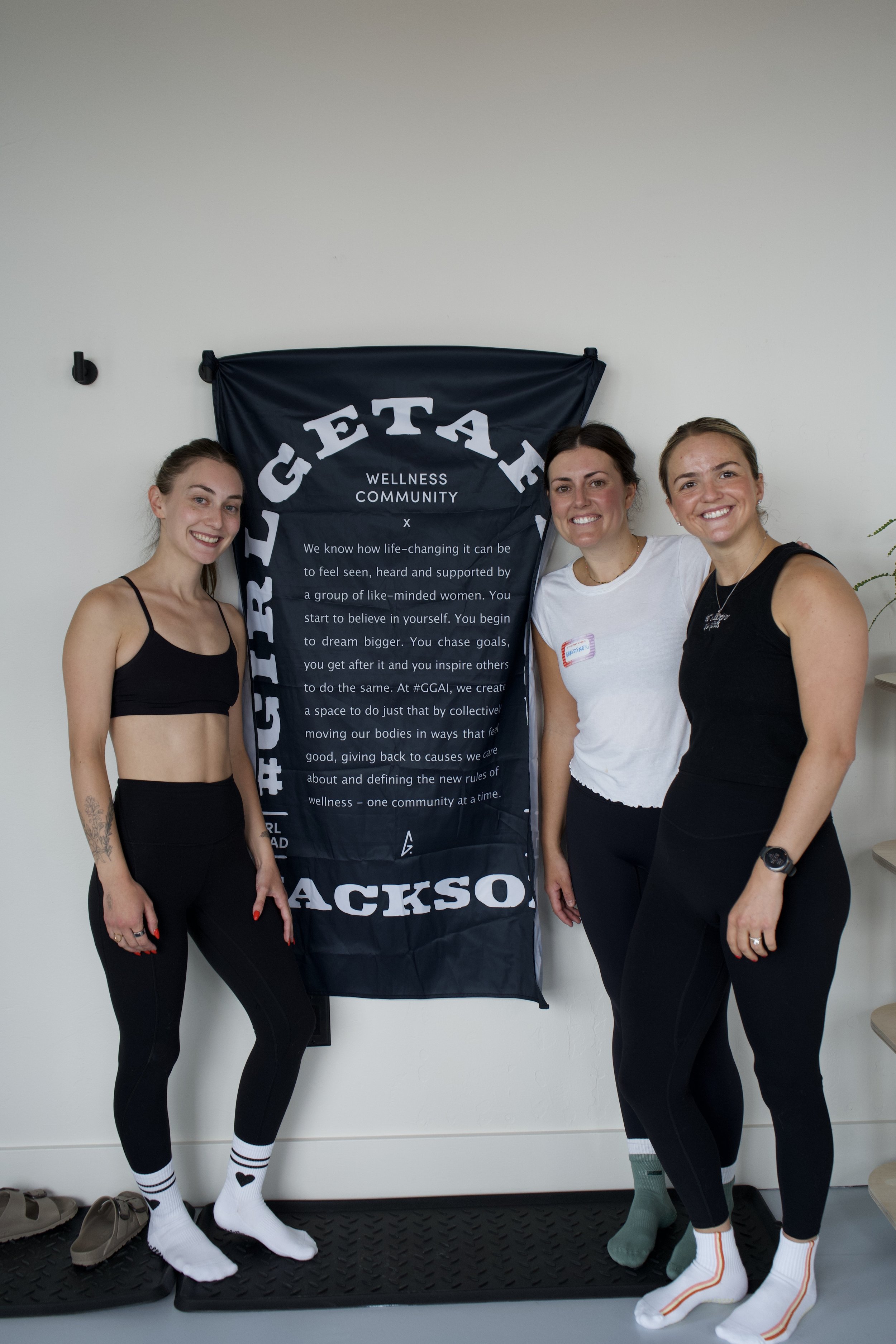 Marge, Christine, and Jordan, the Girl Get After It Jackson Community Leads, beside the Jackson banner