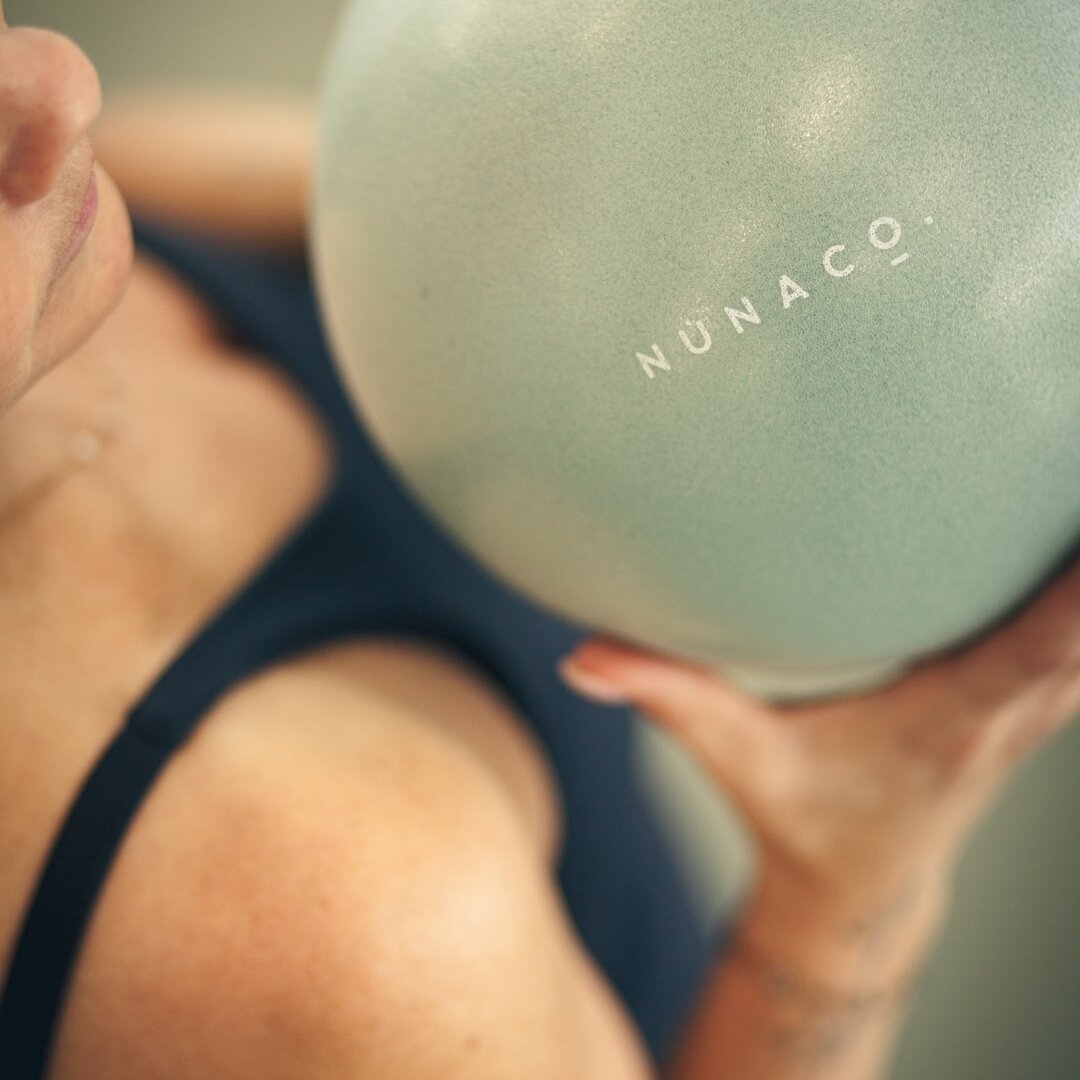 We love leveling up our classes with our secret weapon - the small ball! At N&uacute;na Co. we use the ball during warm-up, mat work, and during barre work. The ball can provide extra lower back support and options for our clients ✨