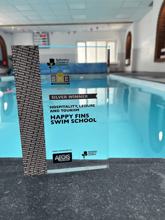 Happy Fins Swim School's Silver Winner award for Hospitality, Leisure and Tourism, displayed by the pool