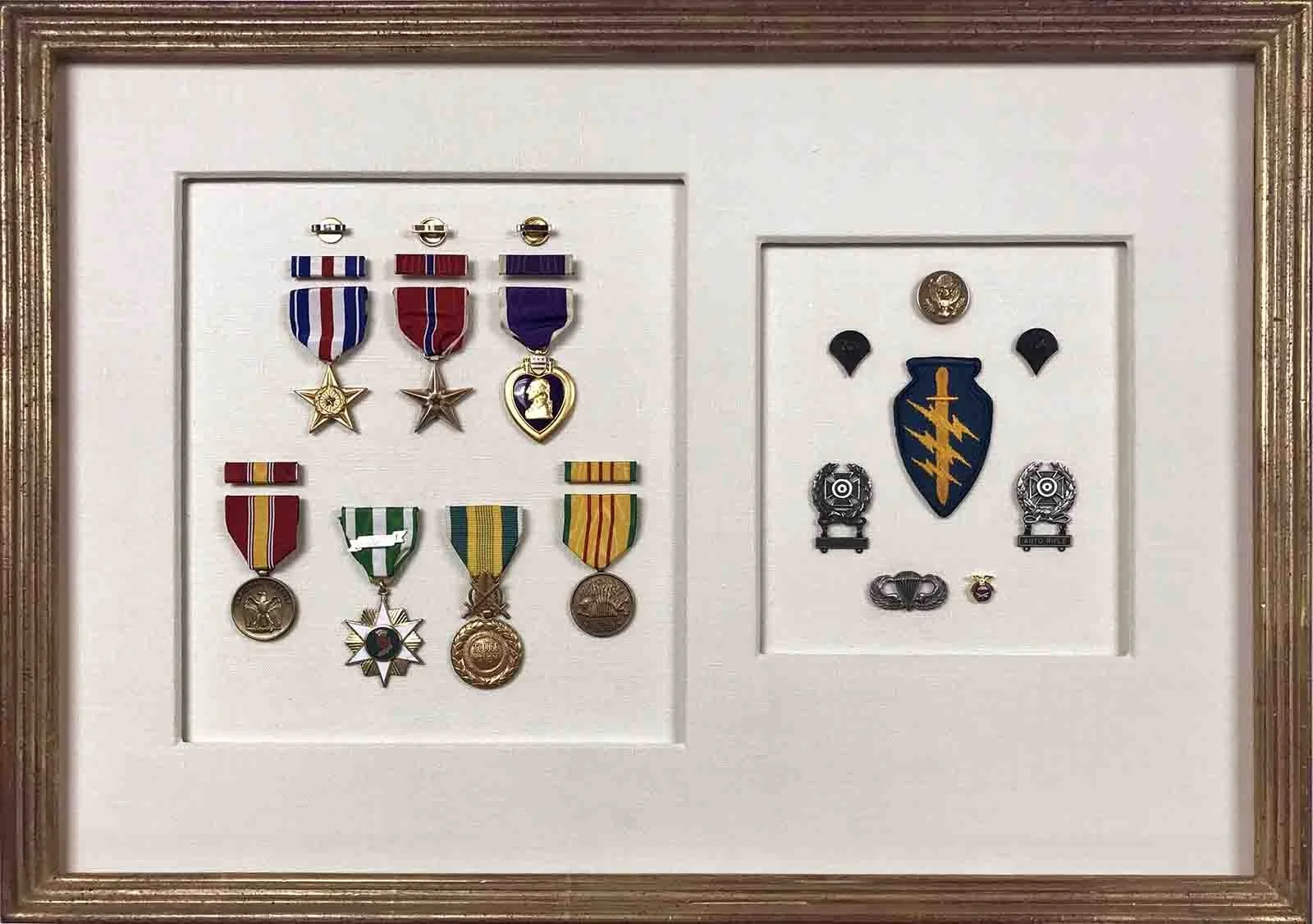 Military regalia floated on hand wrapped cotton matting, in custom finished corner gold leaf frame.