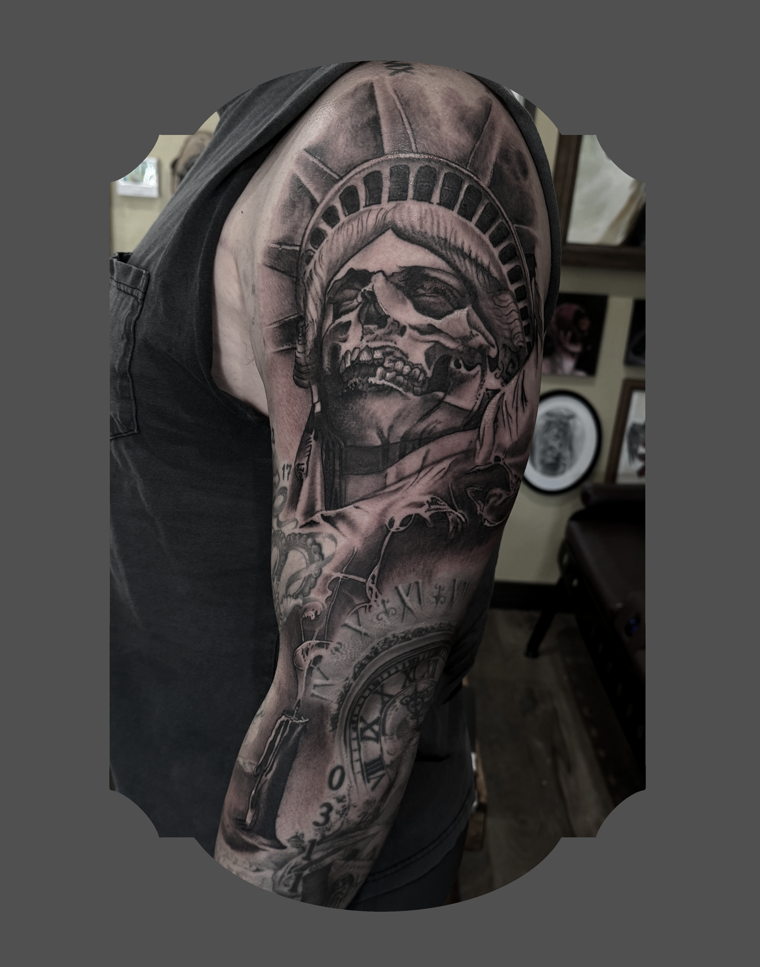 Tattoo sleeve featuring a skull and a clock on a person's upper arm.