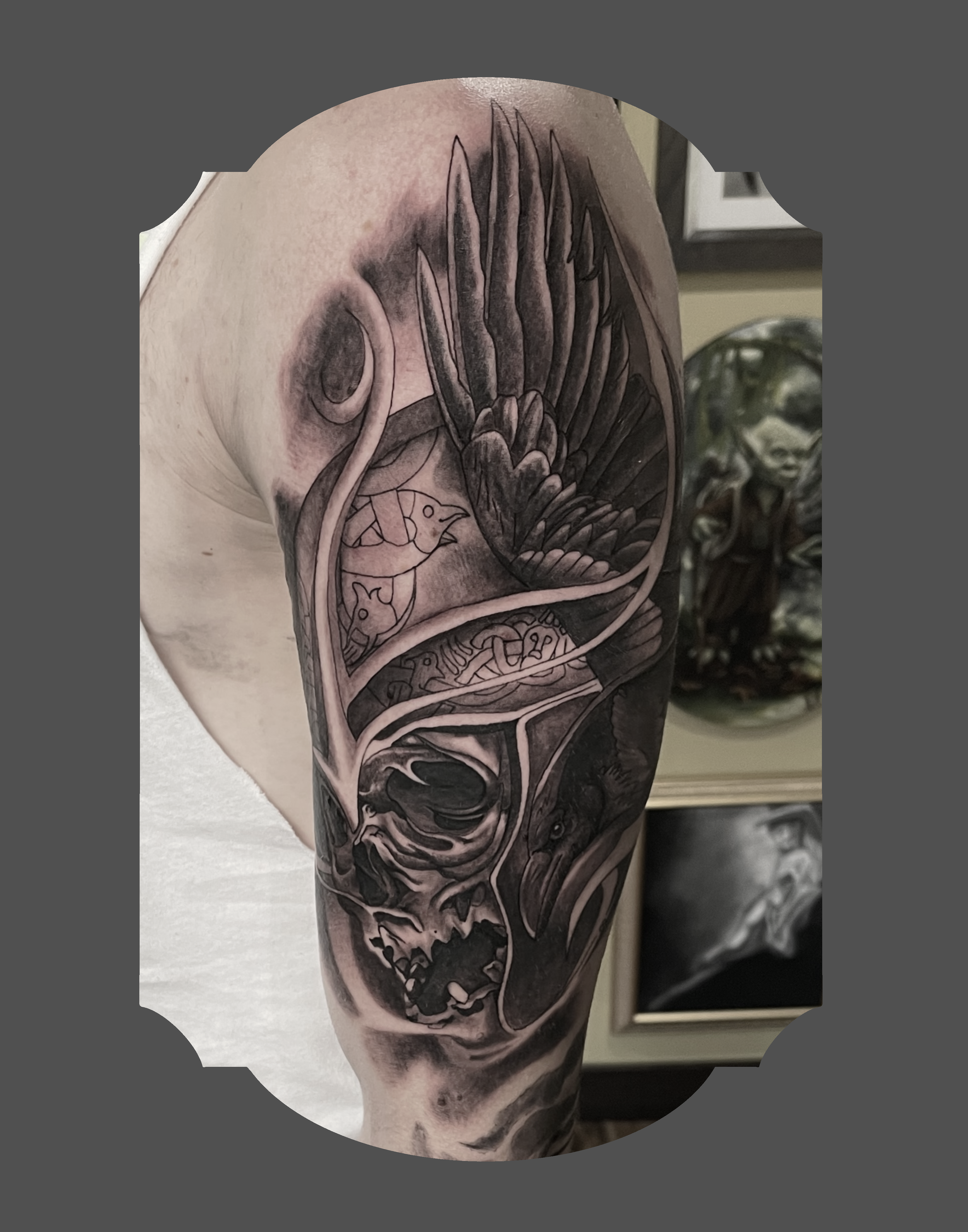 Tattoo of a snake wrapped around a dagger on a person's arm with dark shading and detailed linework.