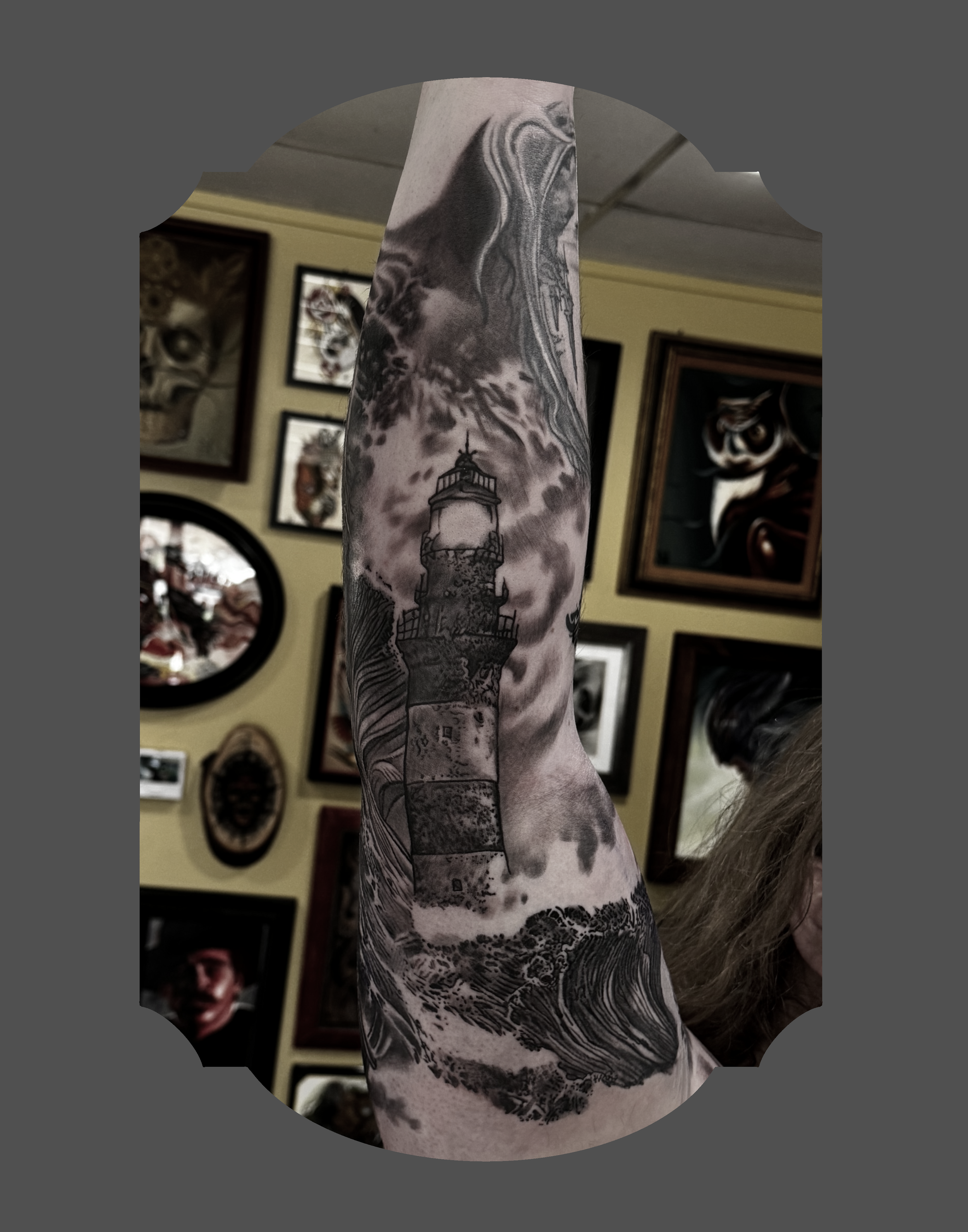 Tattoo sleeve featuring a lighthouse at the bottom, a warthog's head, a stylized lion, a tiger, and swirling abstract patterns in black and gray.