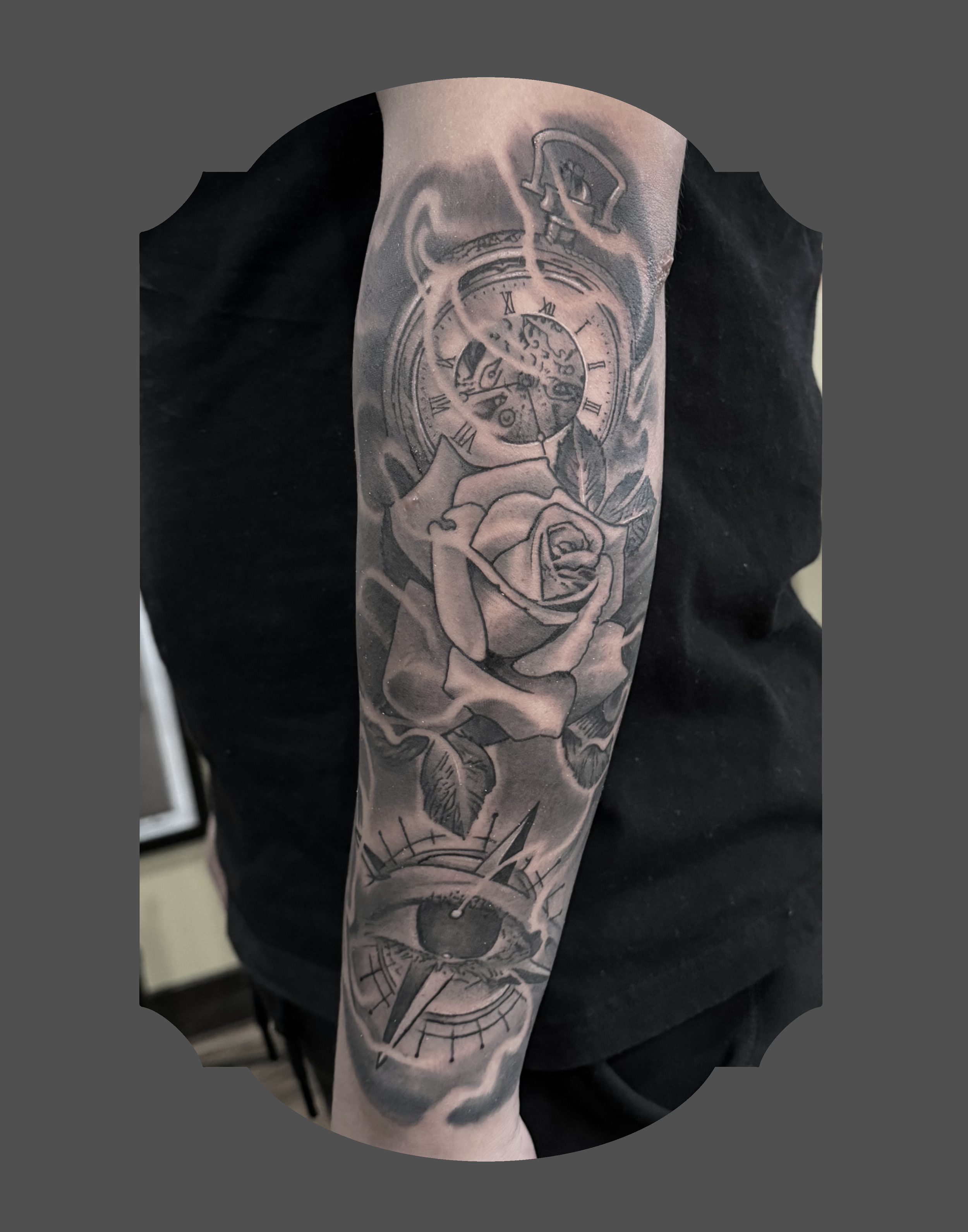 Tattoo of a pocket watch with Roman numerals and a hand holding a rose on a person's arm.