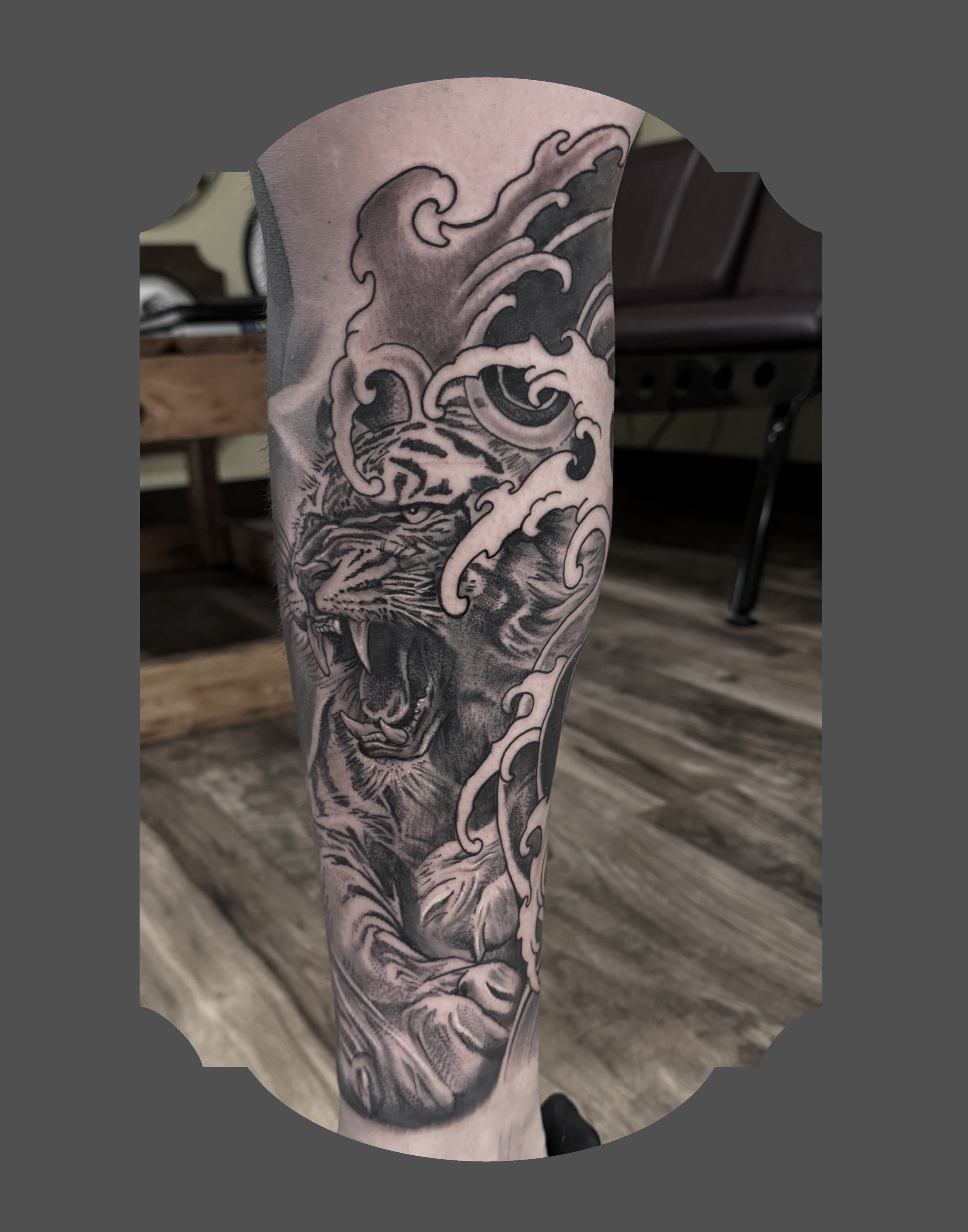 Black and gray tattoo of a traditional Japanese wave design on a person's arm.