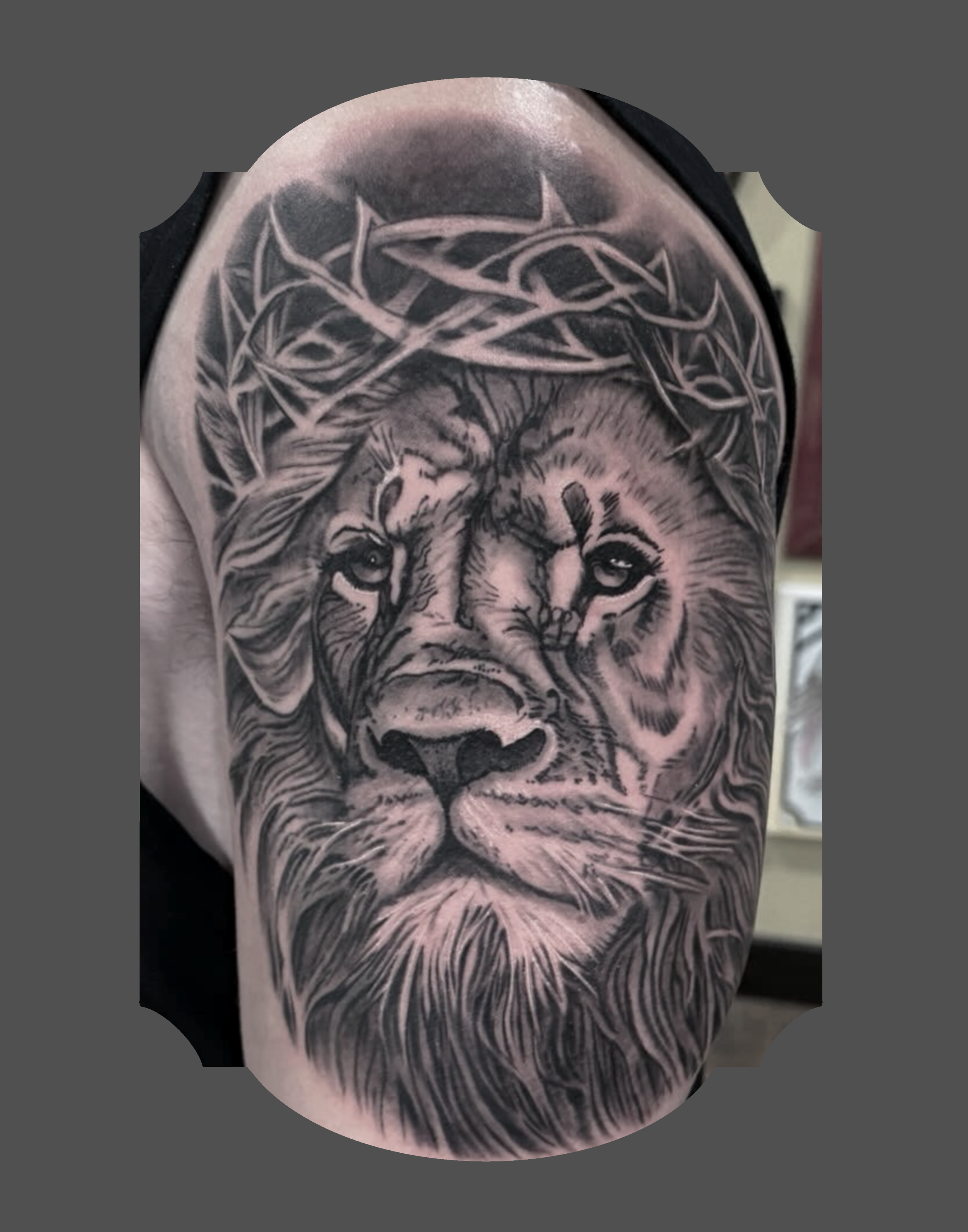 Tattoo of a lion's face on a person's upper arm with a wolf head above it, surrounded by intricate tribal patterns.