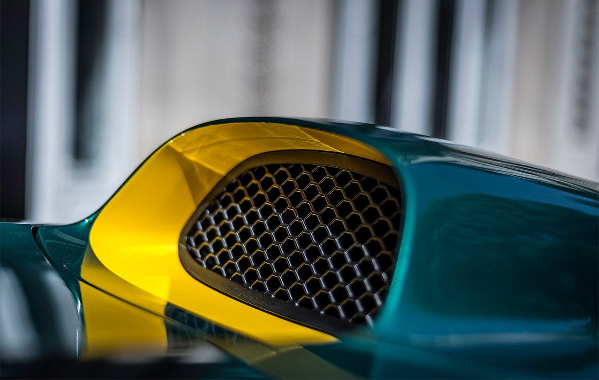 Close-up of a car's front grille with yellow and green paint.