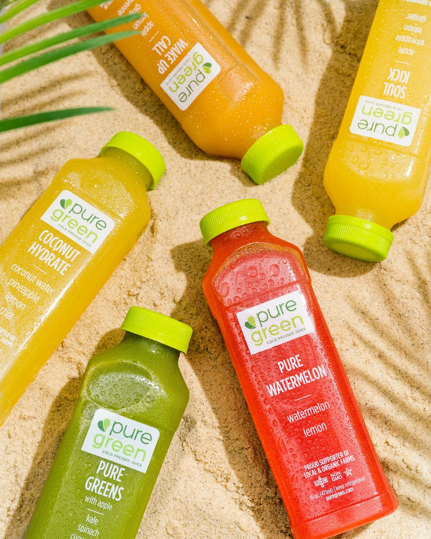Original Pure Green juice bottles photographed on sand